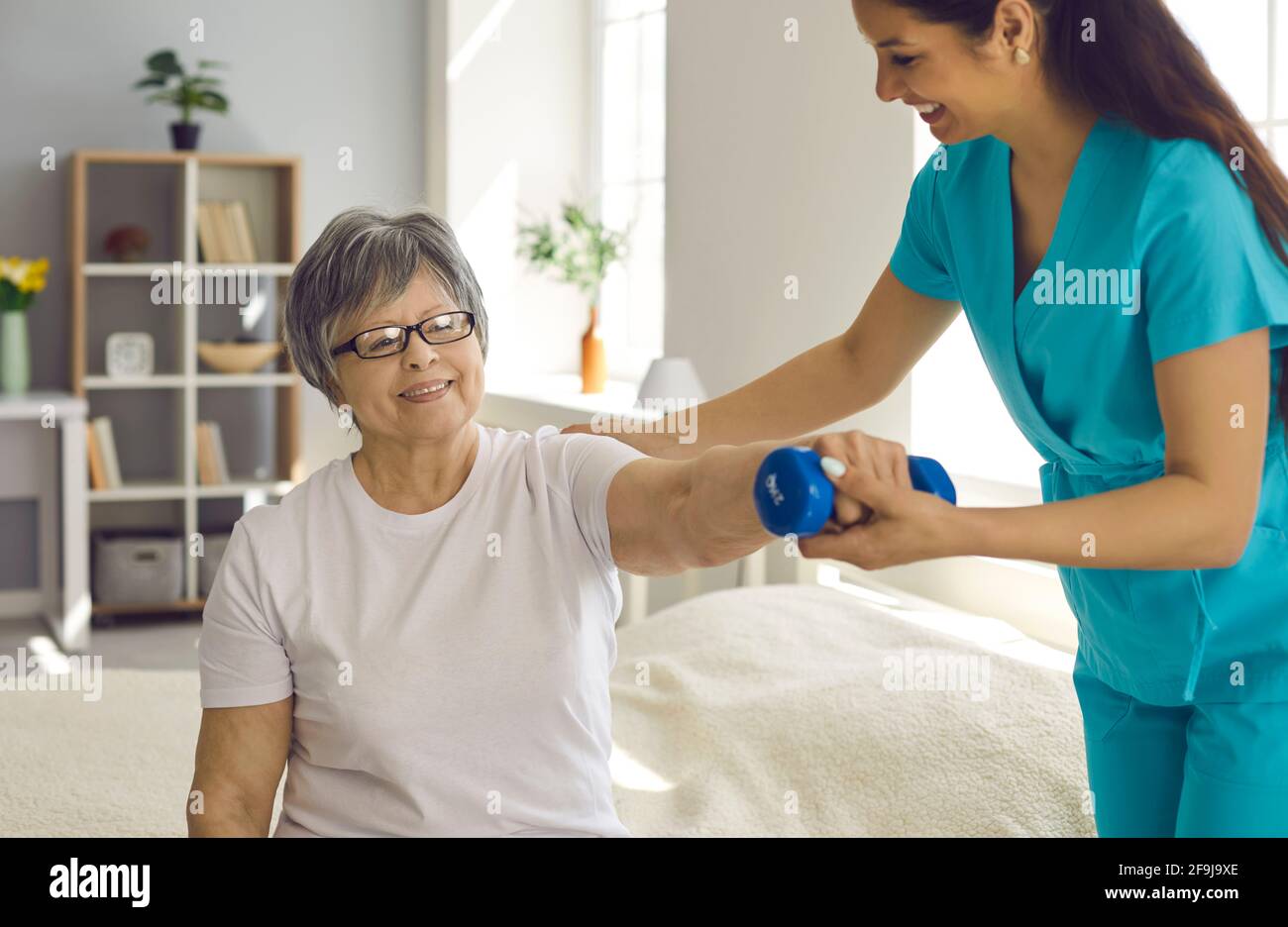 Elderly woman patient rehabilitation with professional nurse help at home Stock Photo