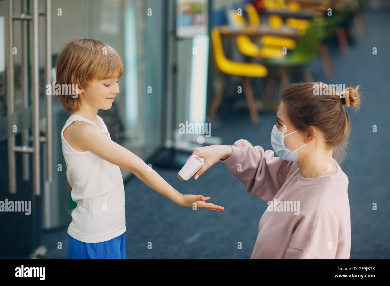 Child temperature measurement by laser thermometer at kindergarten Stock  Photo - Alamy