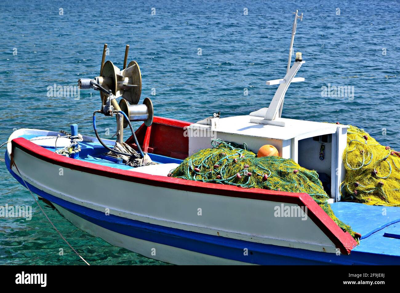 Traditional Greek fishing boat with fishing winch and fishing nets on