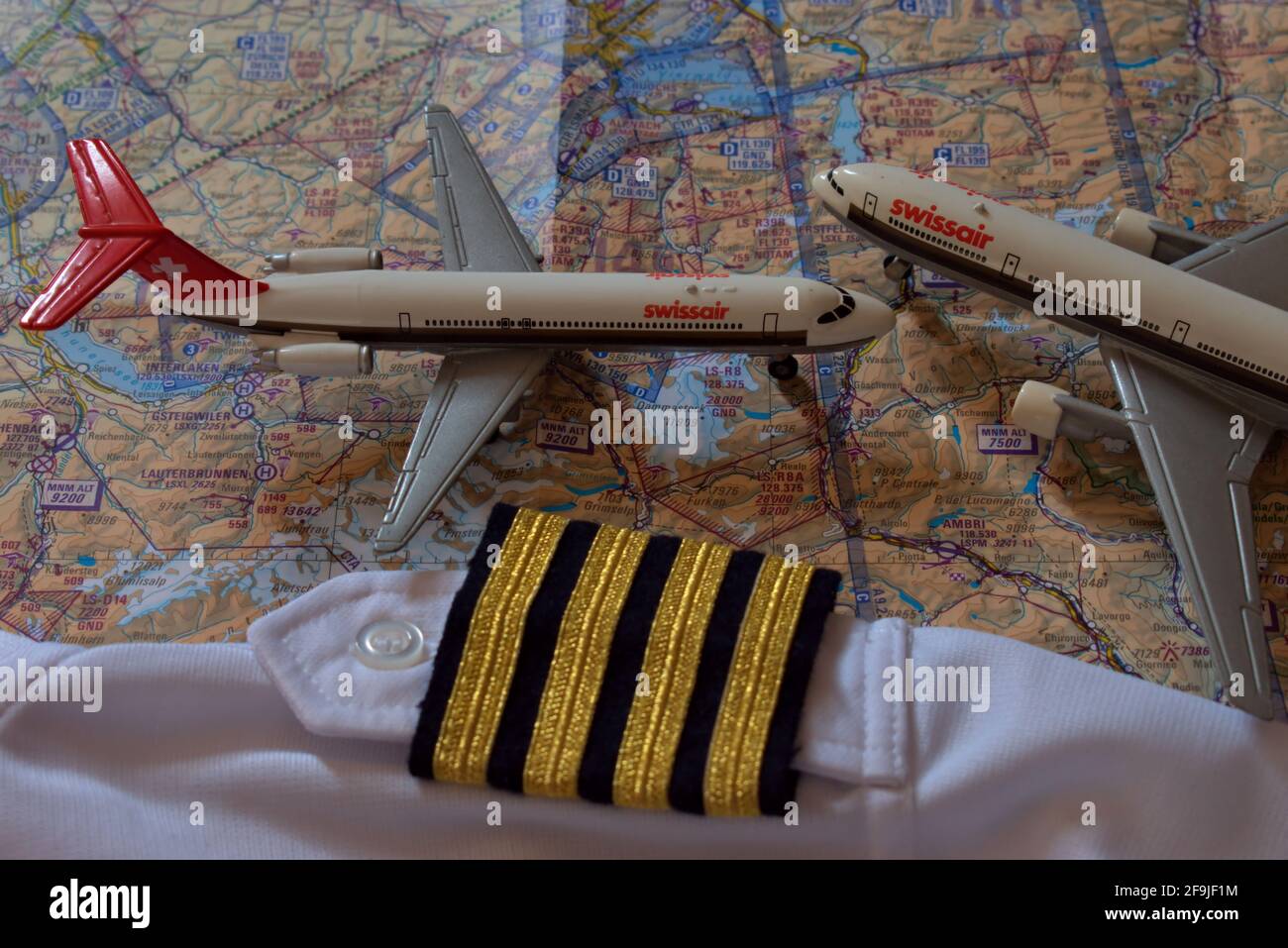 Aircraft toys on an air navigation map and golden captain stripes 25.3.2021 Stock Photo