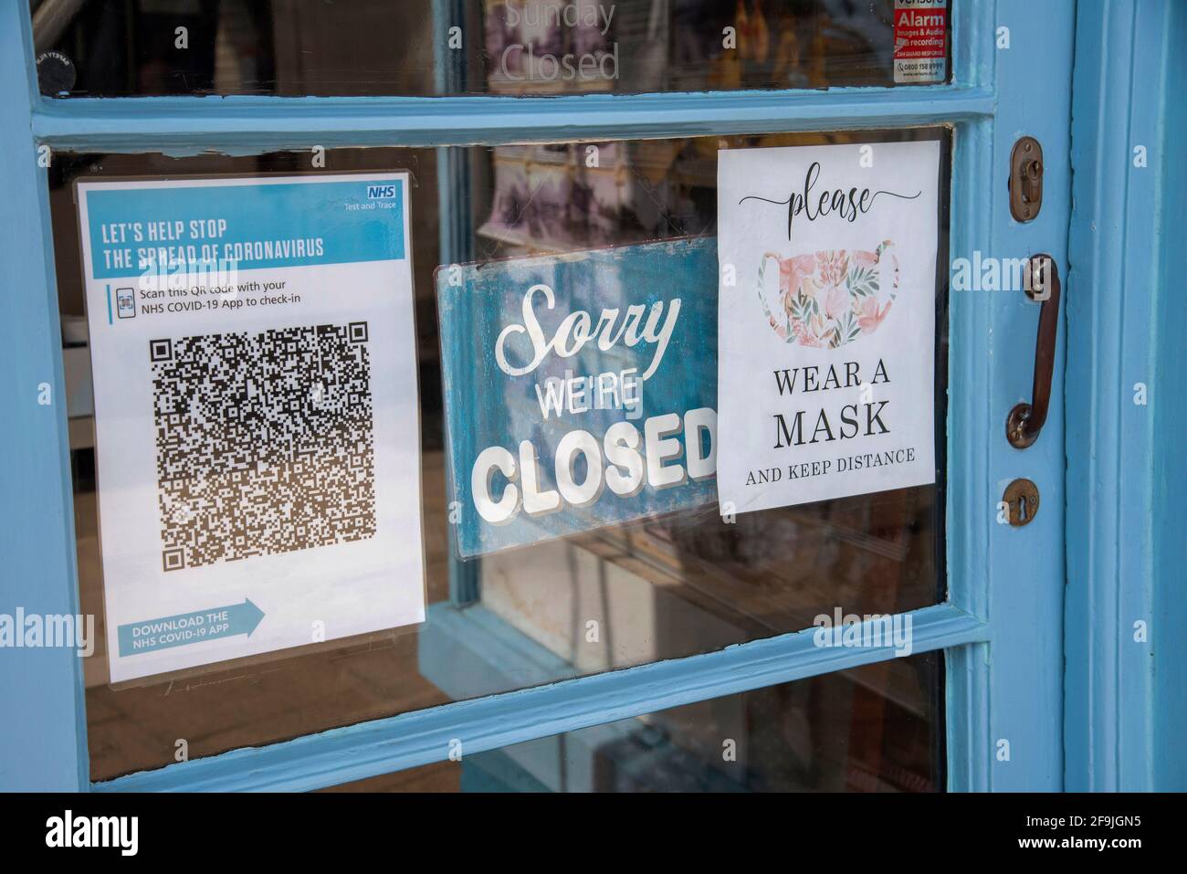 England, UK. 2021.  Shop door with closed sign and Test and Trace Covid-19 QR Code for NHS app. Wear a Mask sign. Stock Photo