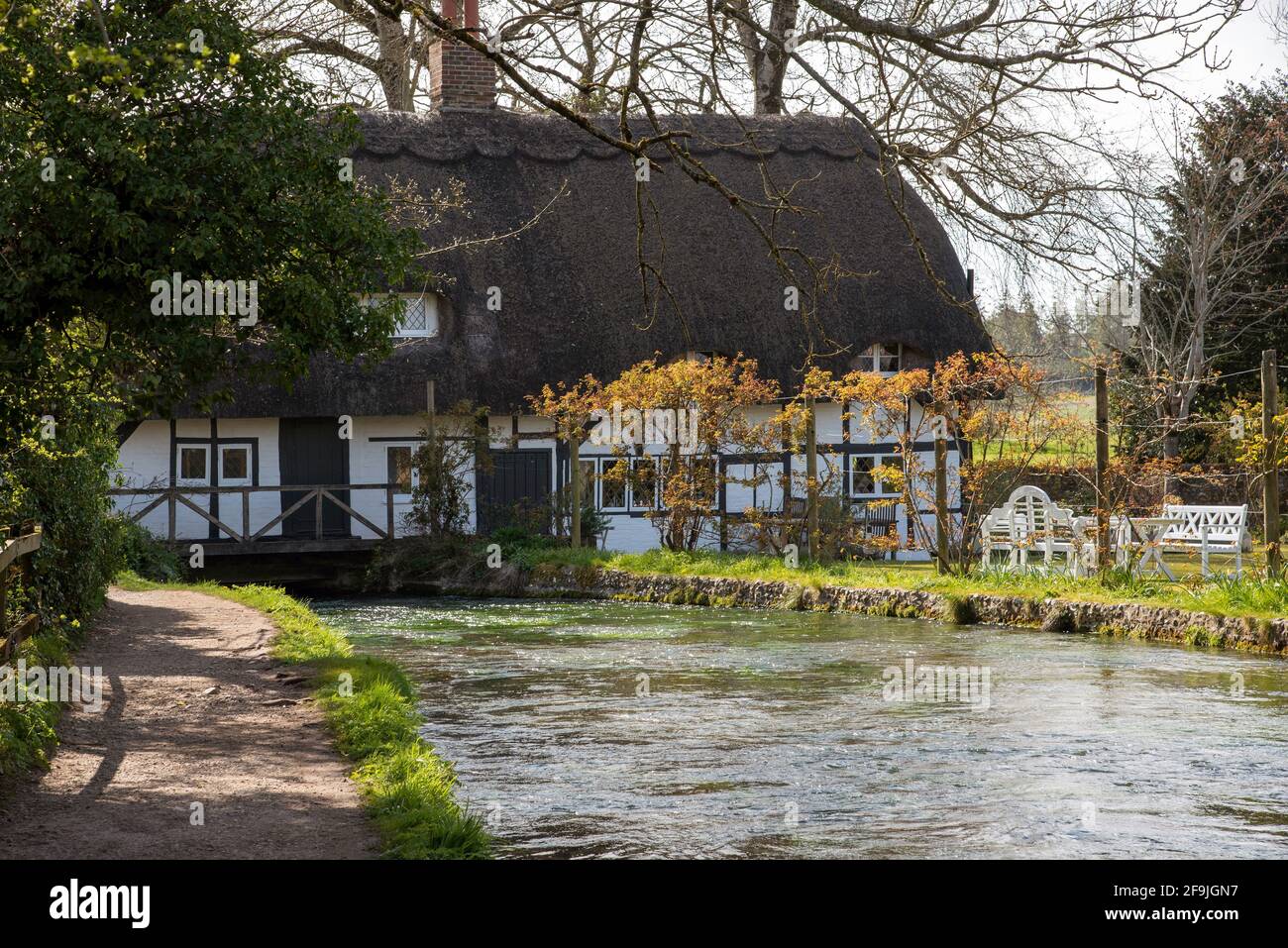 Alresford, Hampshire, England, UK. 2021,  The Fulling Mill a historic thatched building with the fast flowing River Arle passing below the building. R Stock Photo