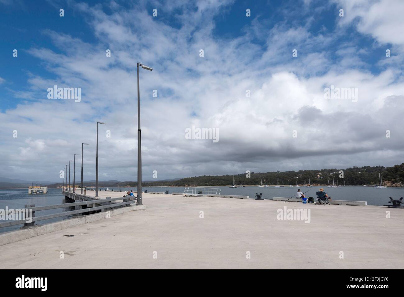 February 2021 Eden, NSW, Australia: the newly extended wharf in the deep port of Eden hosts only a few fishermen as large cruise ships during Covid-19 Stock Photo