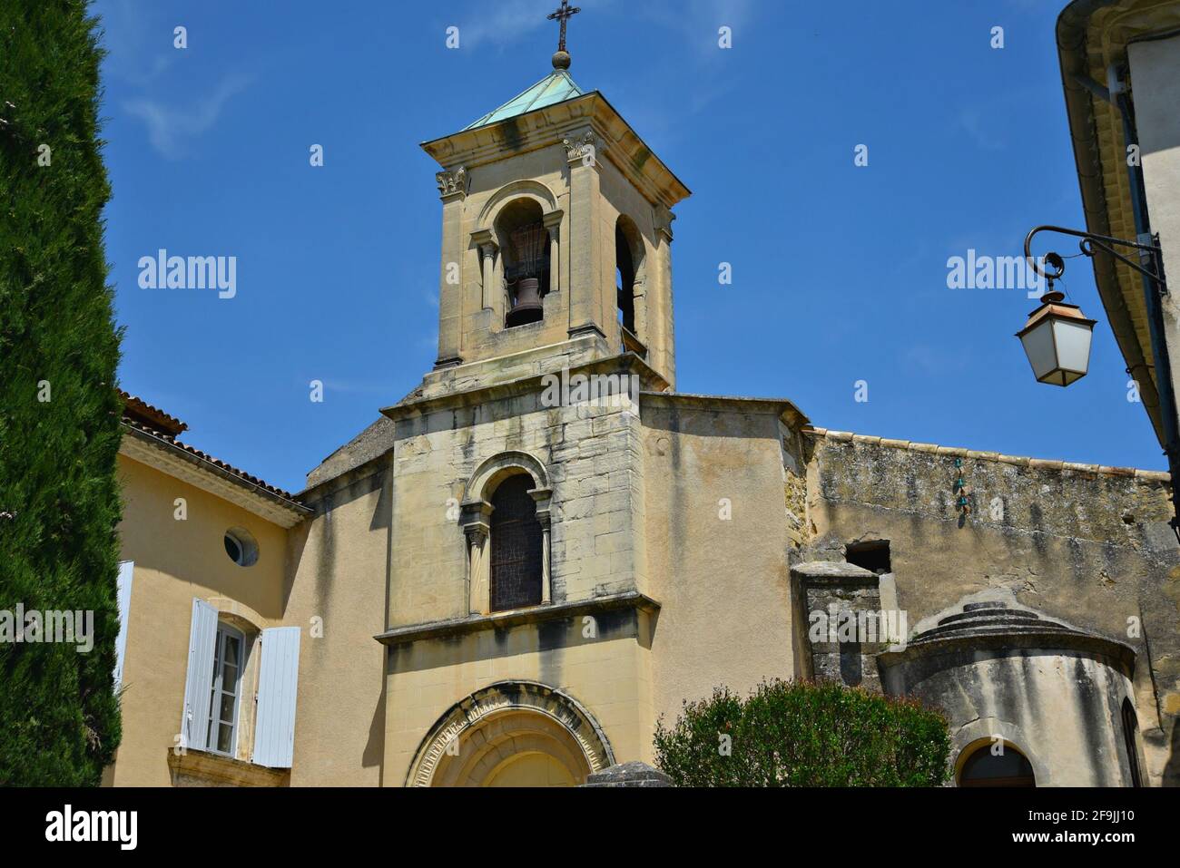 Facade and belfry of the Romanesque style church Saint-André-et-Saint-Trophime in the picturesque village of Lourmarin in Vaucluse, Provence France. Stock Photo