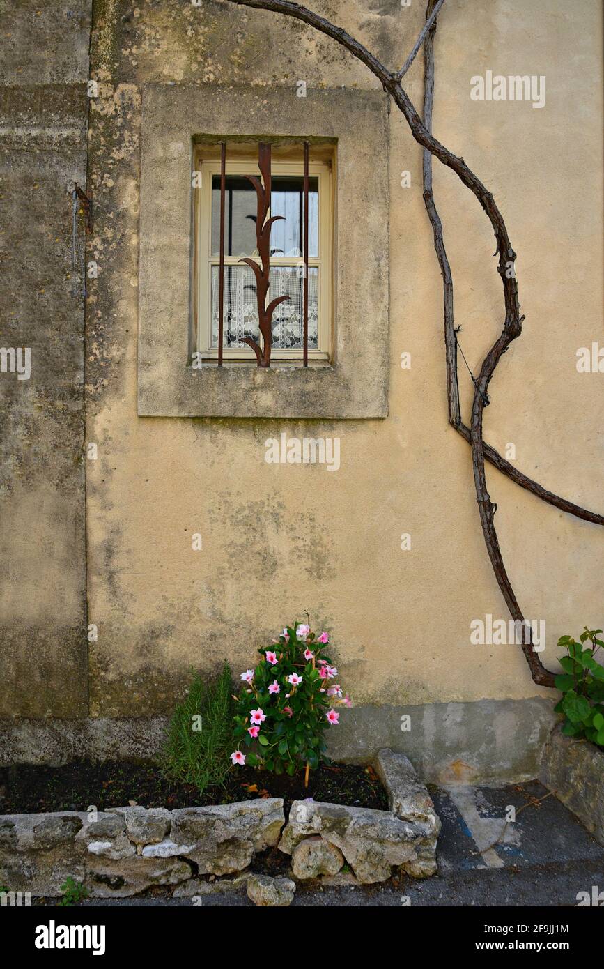 Provençal style rural house facade with a window on a weathered ochre wall in the picturesque village of Lourmarin in Vaucluse, Provence France. Stock Photo