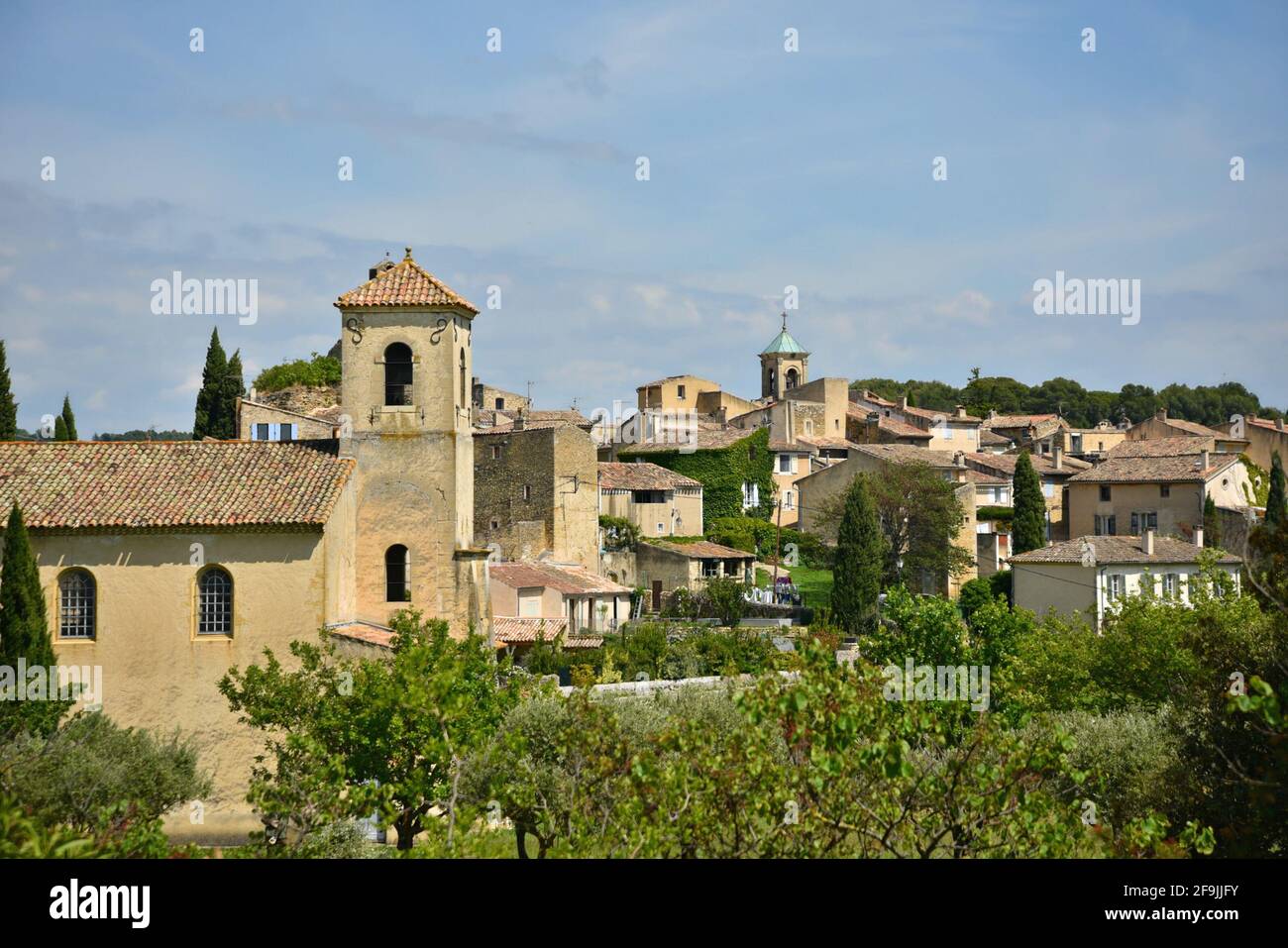 Landscape with scenic view of the Protestant Temple and Provençal style rural houses in the picturesque village of Lourmarin Vaucluse Provence France. Stock Photo