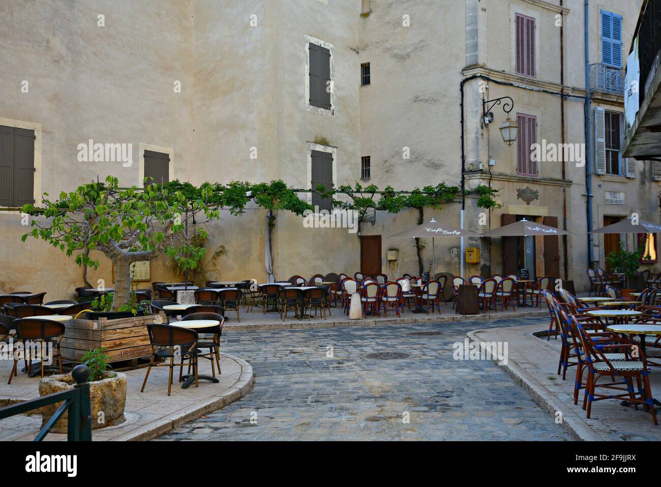 Typical Provençal style houses and local cafes on the main square of the picturesque village of Lourmarin in Vaucluse, Provence France. Stock Photo