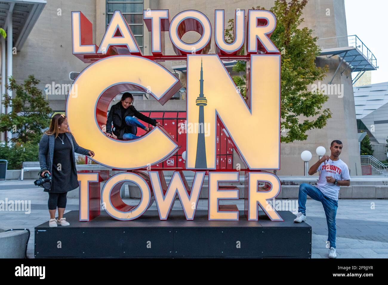 Tourists having their picture taken at the CN Tower sign, Toronto, Canada Stock Photo