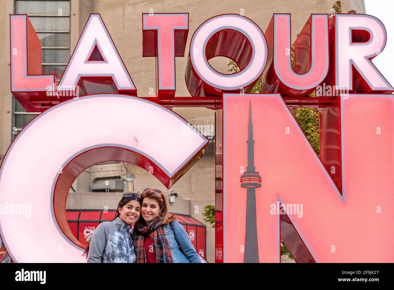 Tourists having their picture taken at the CN Tower sign, Toronto, Canada Stock Photo