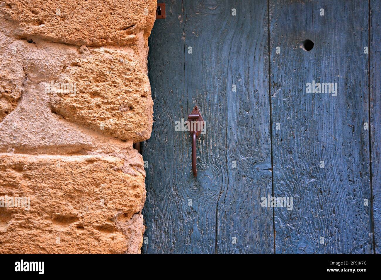Typical Provençal style blue weathered wooden door on a stone wall in the picturesque village of Lourmarin in Vaucluse, Provence France. Stock Photo