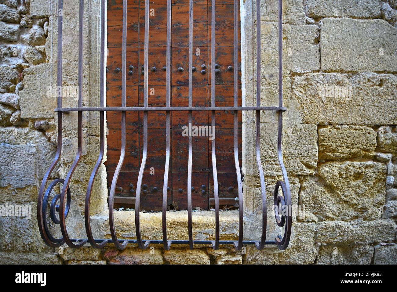 Provençal style rural house oak wooden window with handcrafted iron grilles in the picturesque village of Lourmarin in Vaucluse, Provence France. Stock Photo