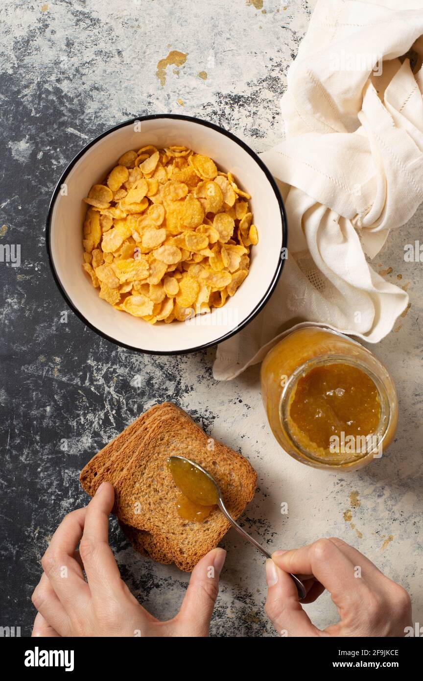 Breakfast with a bowl full of cereal, mandarin marmelade and toasted