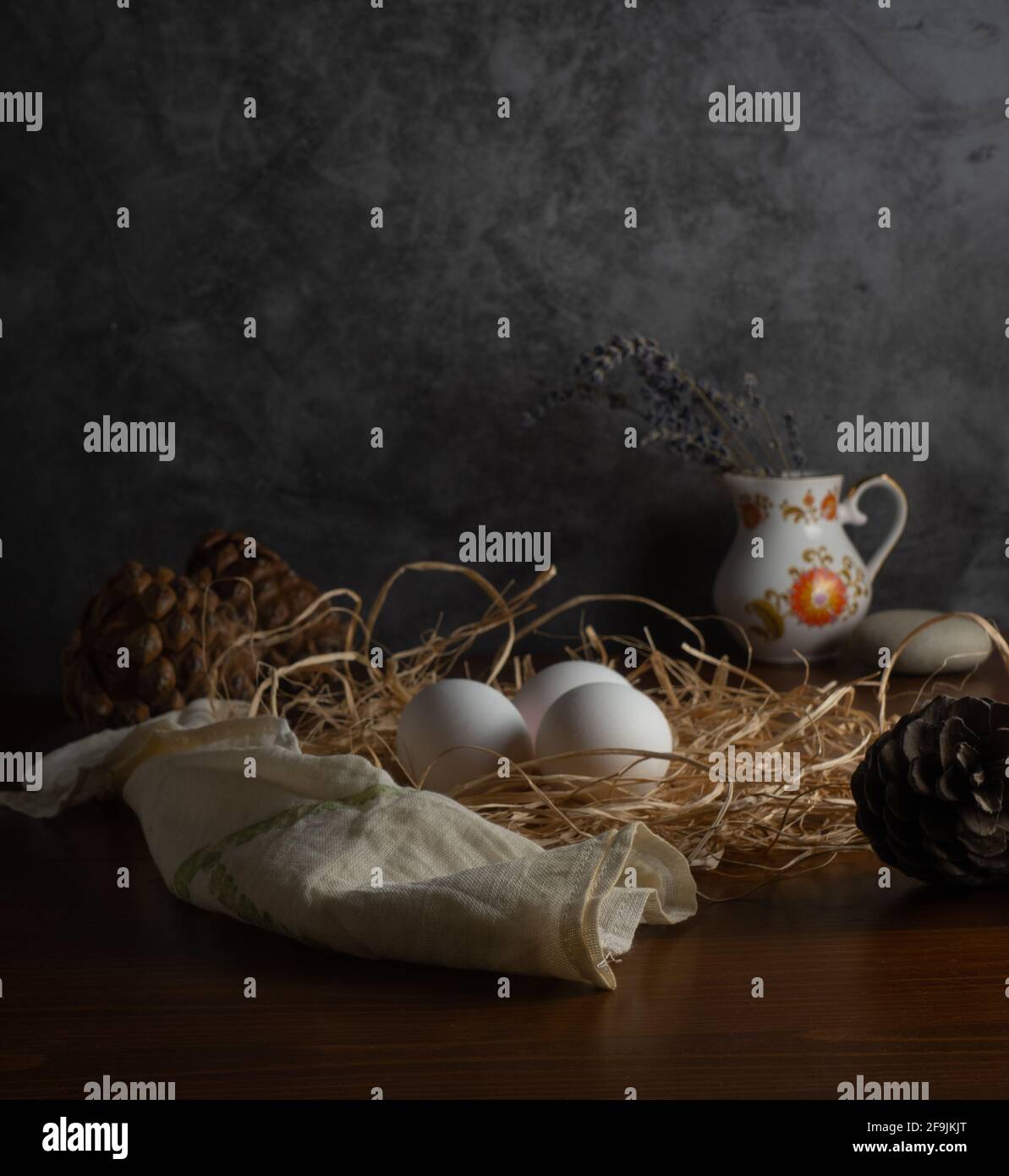 Organic Chicken Eggs in nest with mushroom, wheat ear, corn, pine cone and lavender with dark food photography concept, farm concept Stock Photo