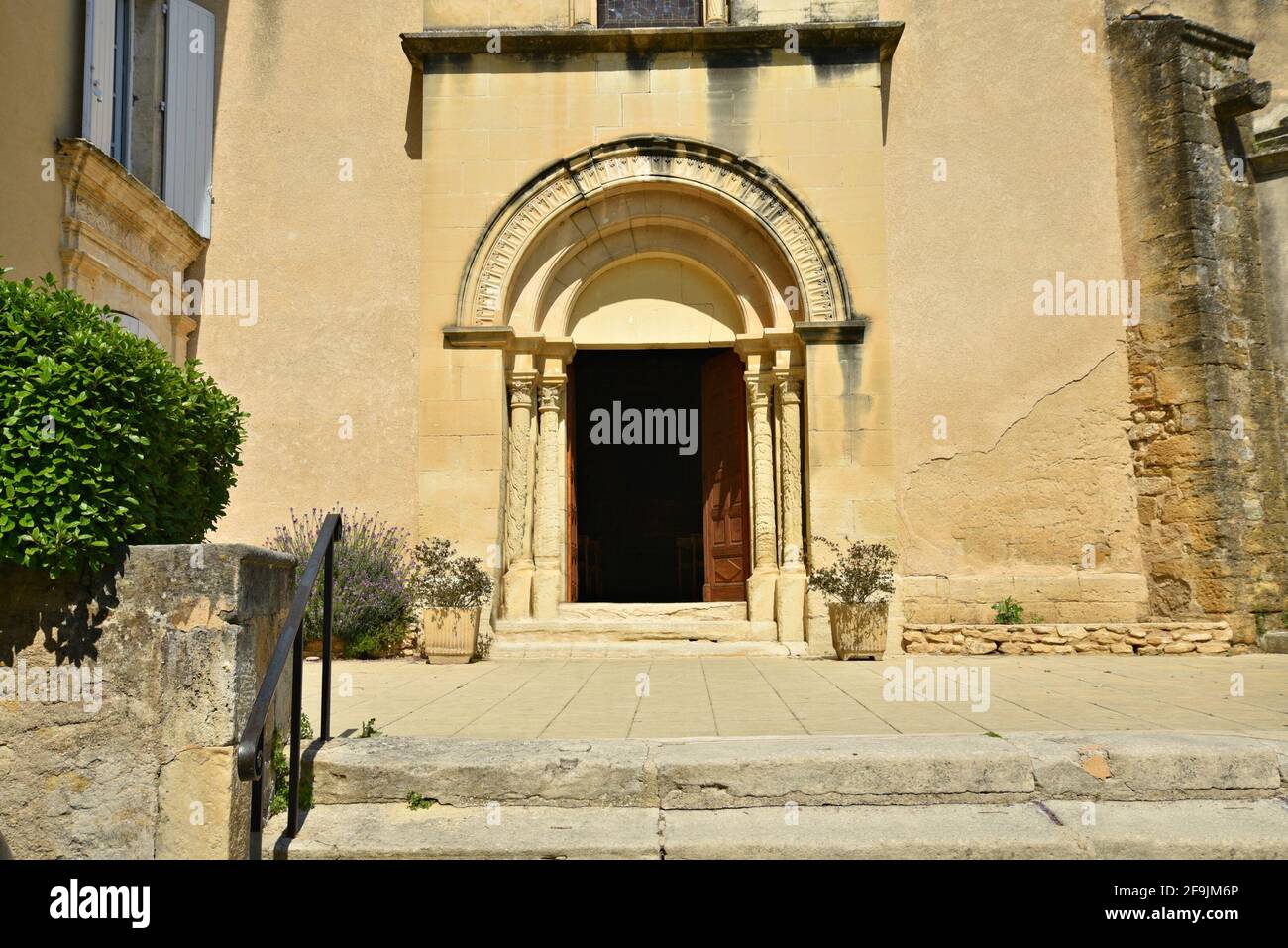 Facade view of Saint-Trophime and Saint-André the Romanesque church on the main square of Lourmarin in Vaucluse, Provence-Alpes-Côte d'Azur, France. Stock Photo