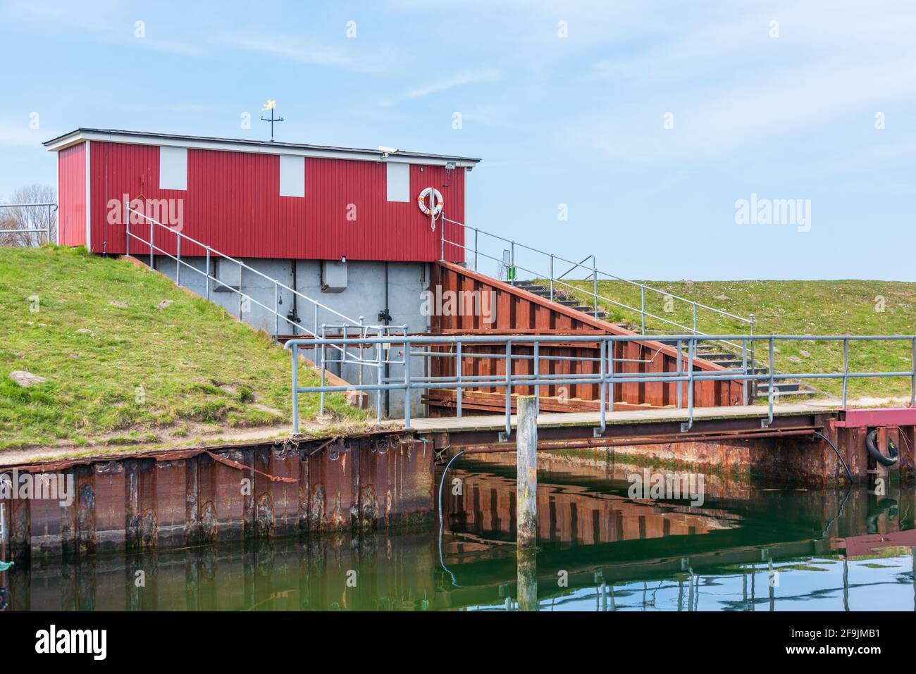 Der idyllische Hafen Lippe an der Hohwachter Bucht in Schleswig-Holstein, das Schleusengebäude am deich zum Schutz des Achterwassers Stock Photo