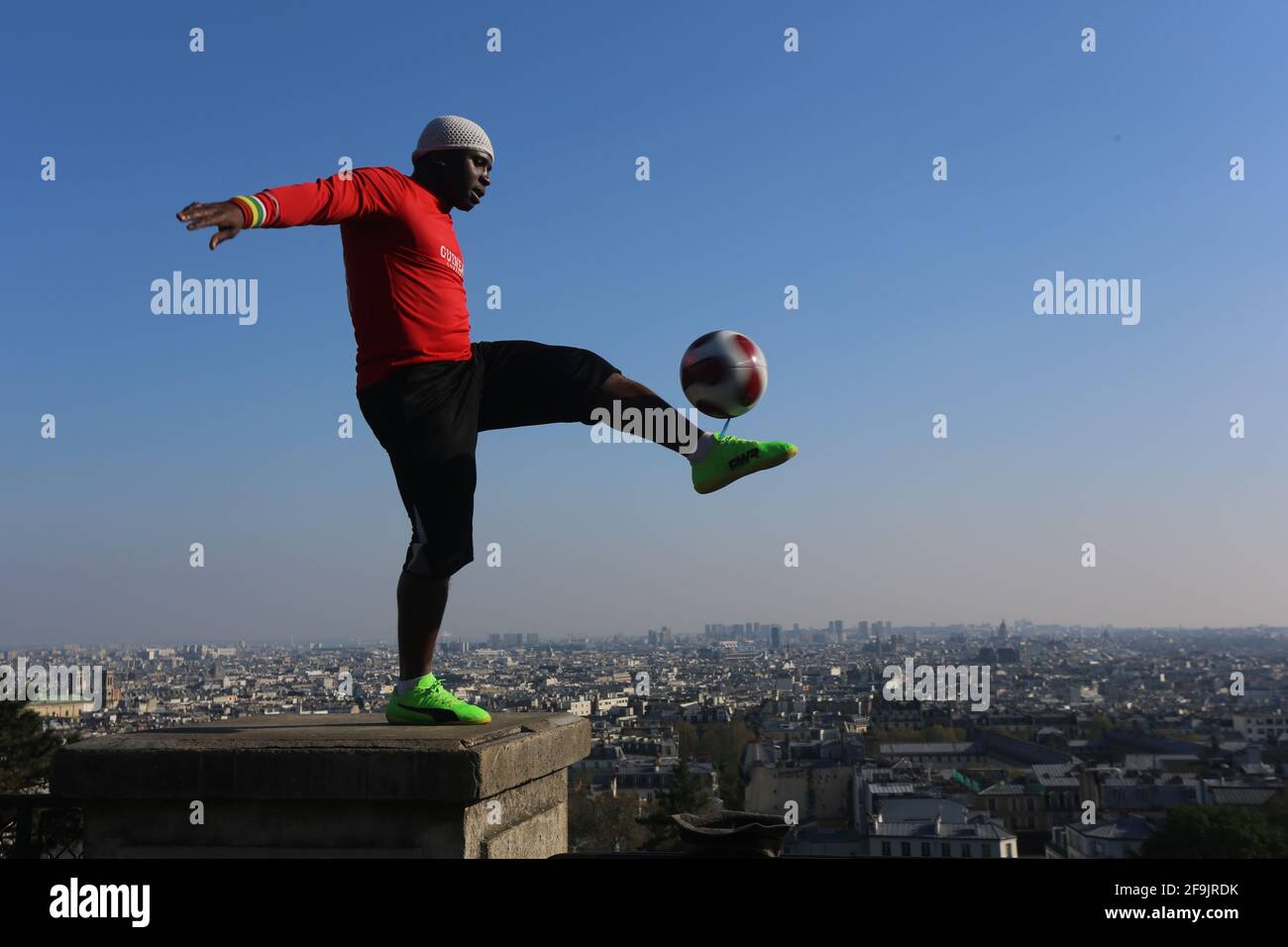 Ball Artist und Fußball Künstler spielt über den Dächern von Paris Stock Photo