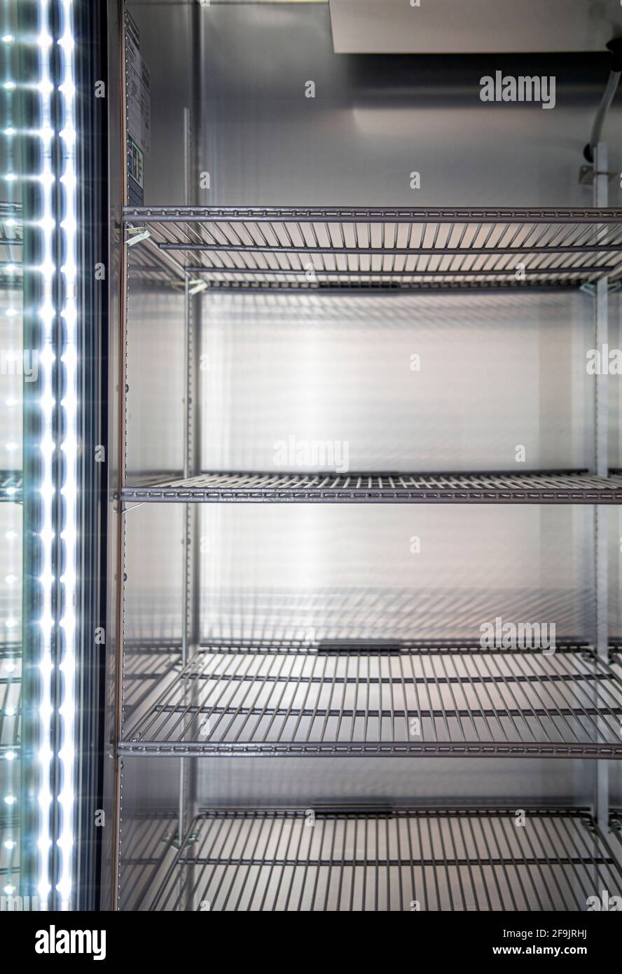 Clean and empty commercial fridge shelves Stock Photo