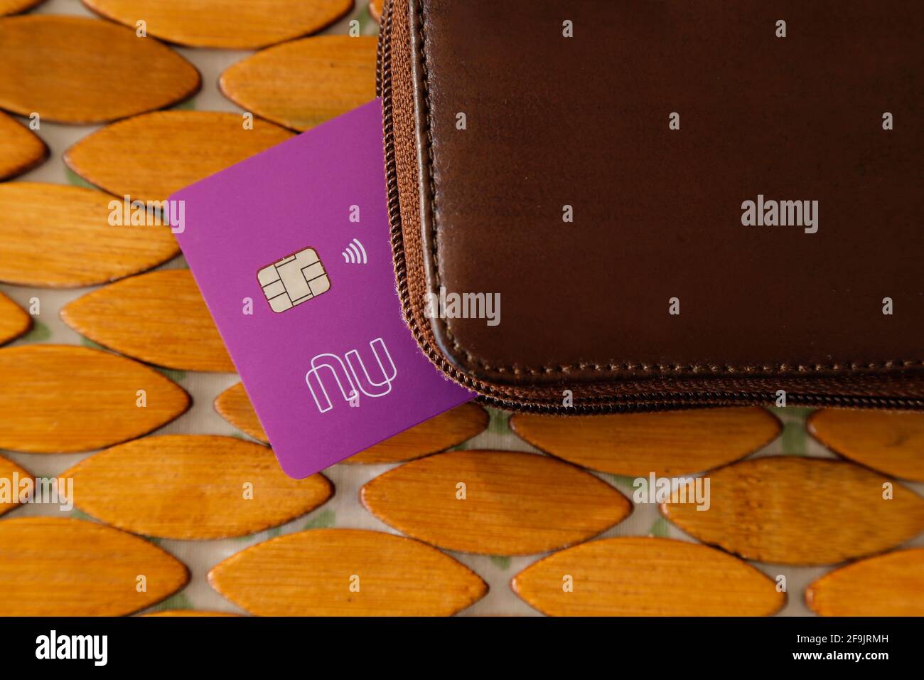 Minas Gerais, Brazil - January 19, 2021: purple credit card with Nubank logo and leather wallet. Form of payment. Stock Photo