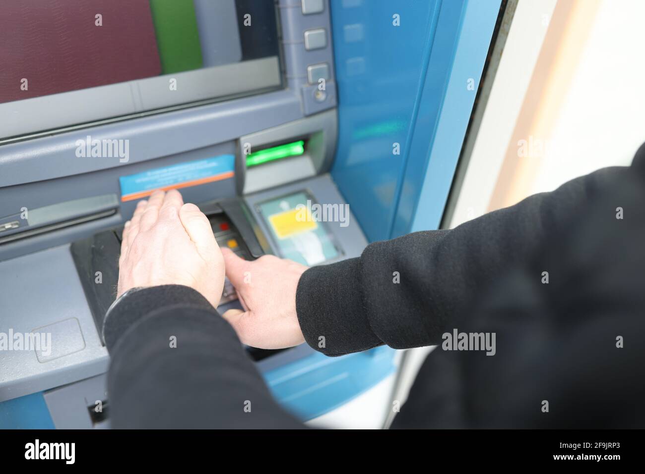 Man entering pin code at ATM and covering it with his hand closeup Stock  Photo - Alamy