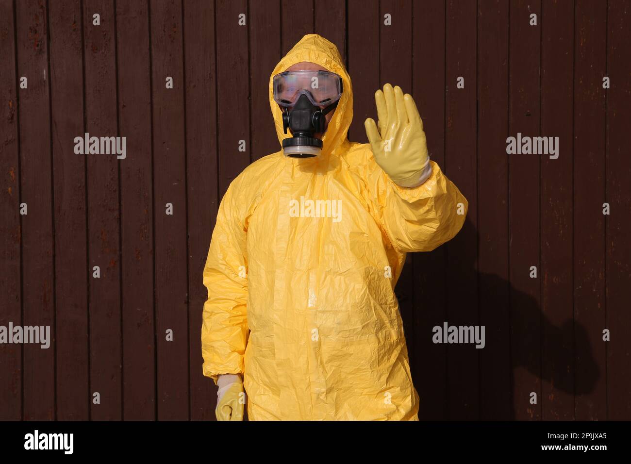 Mann im Schutzanzug hebt die Hand - workwear and protective clothing Stock Photo