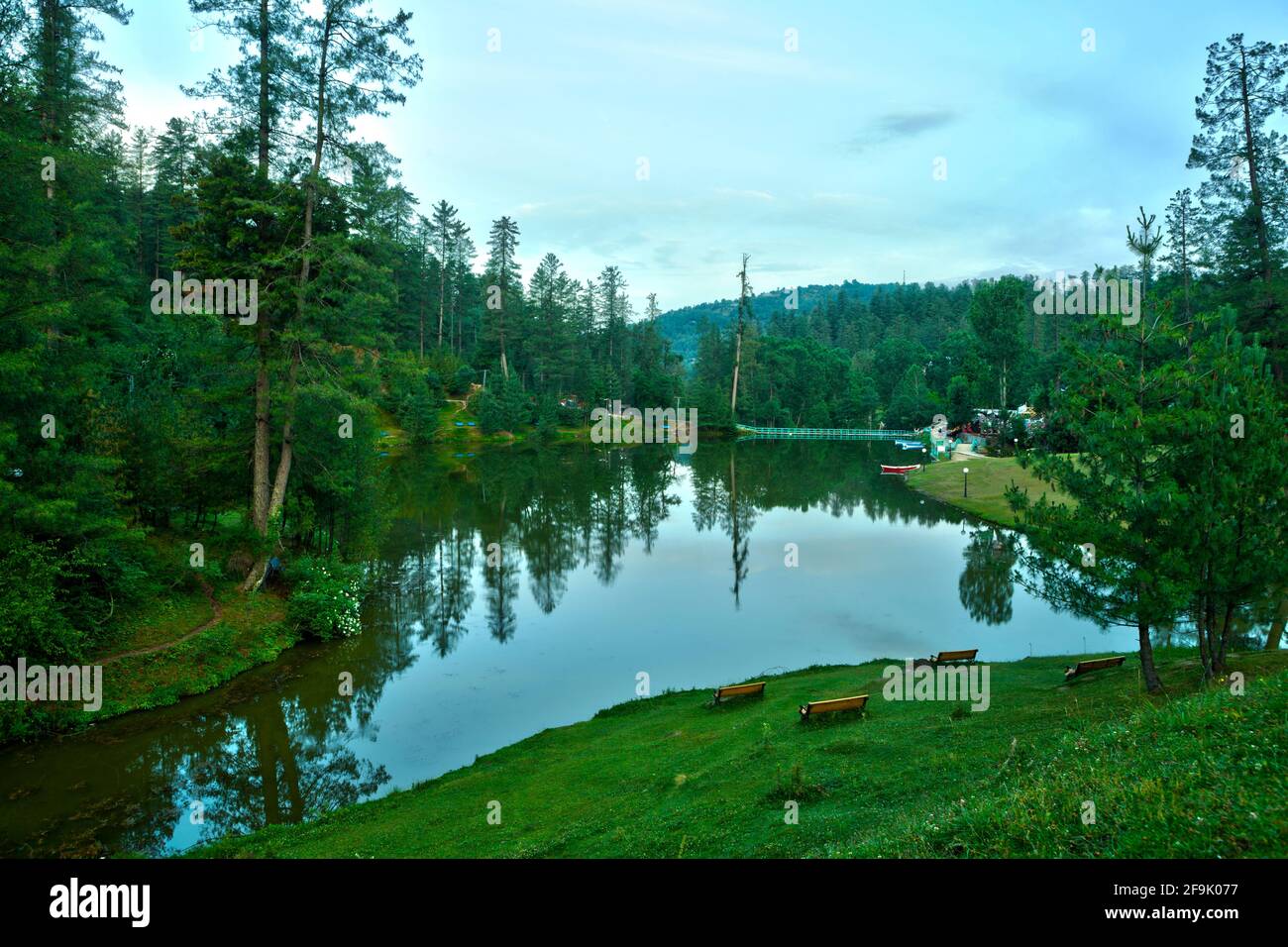 Pine and Deciduous forest reflection in Banjosa Lake in Rawalakot District of Pakistan Administered Kashmir known as Azad Kashmir. Stock Photo
