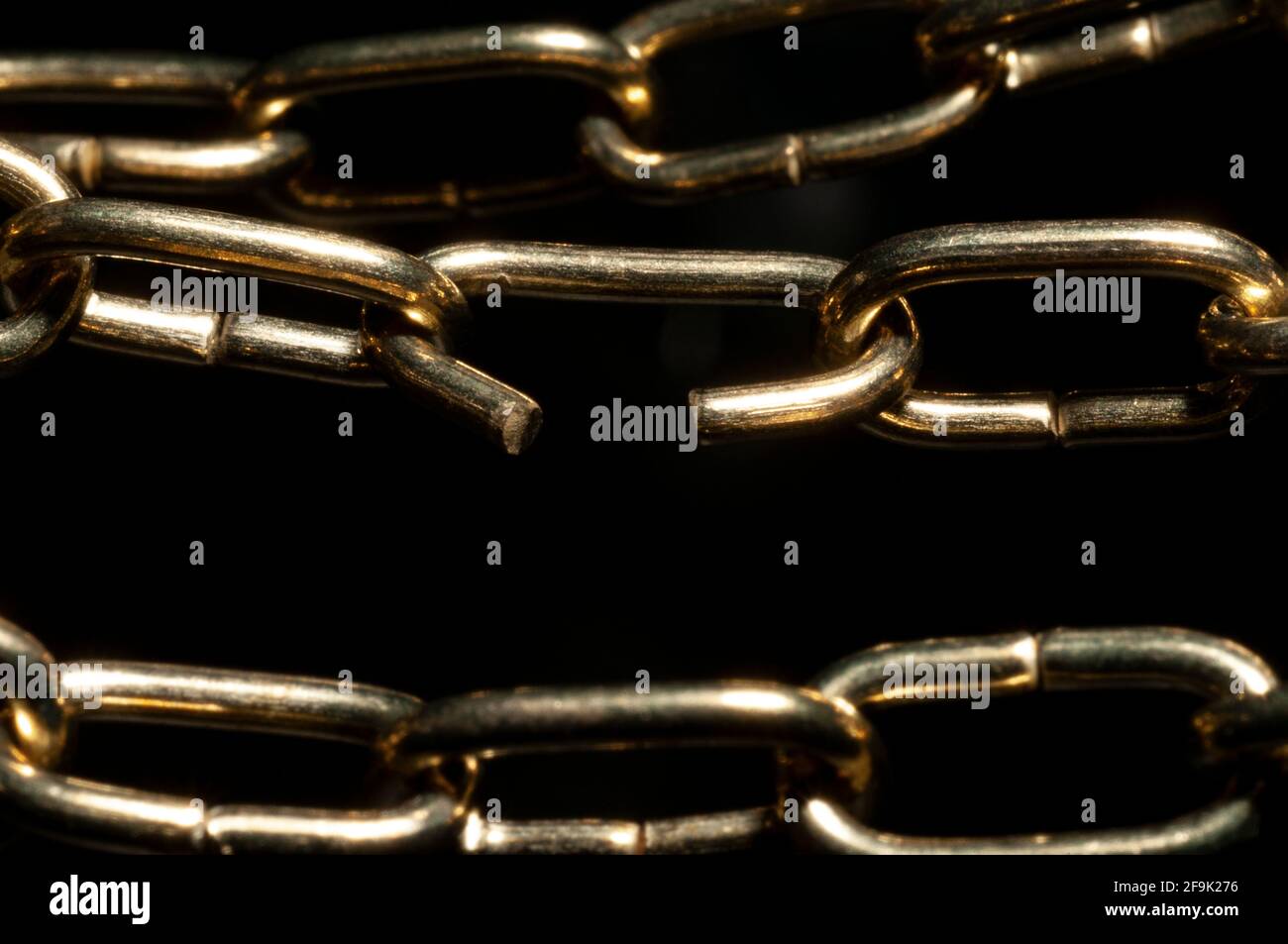 Brass weak link chain in black background Stock Photo Alamy