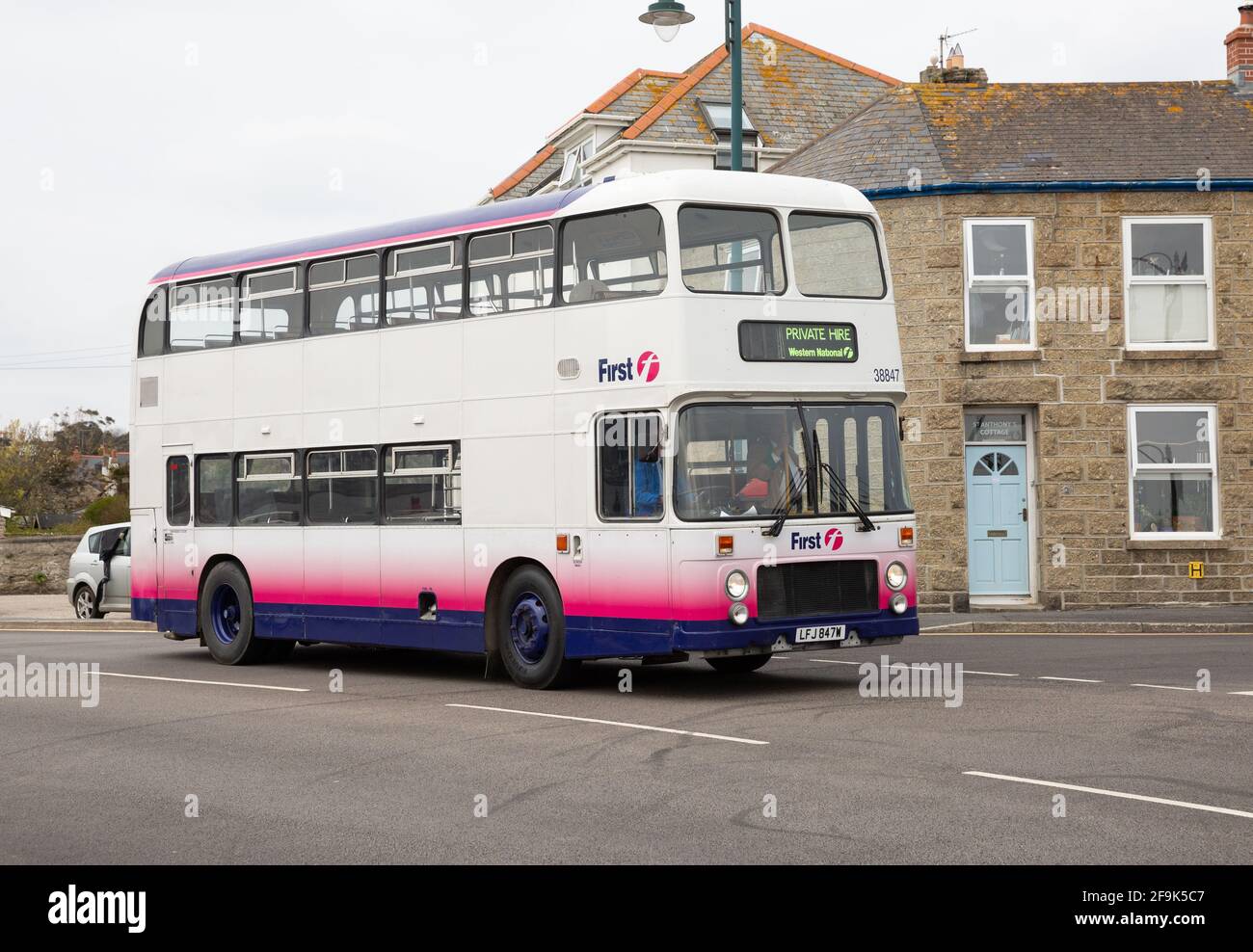 First Double decker bus driving through Penzance, Cornwall, UK Stock Photo