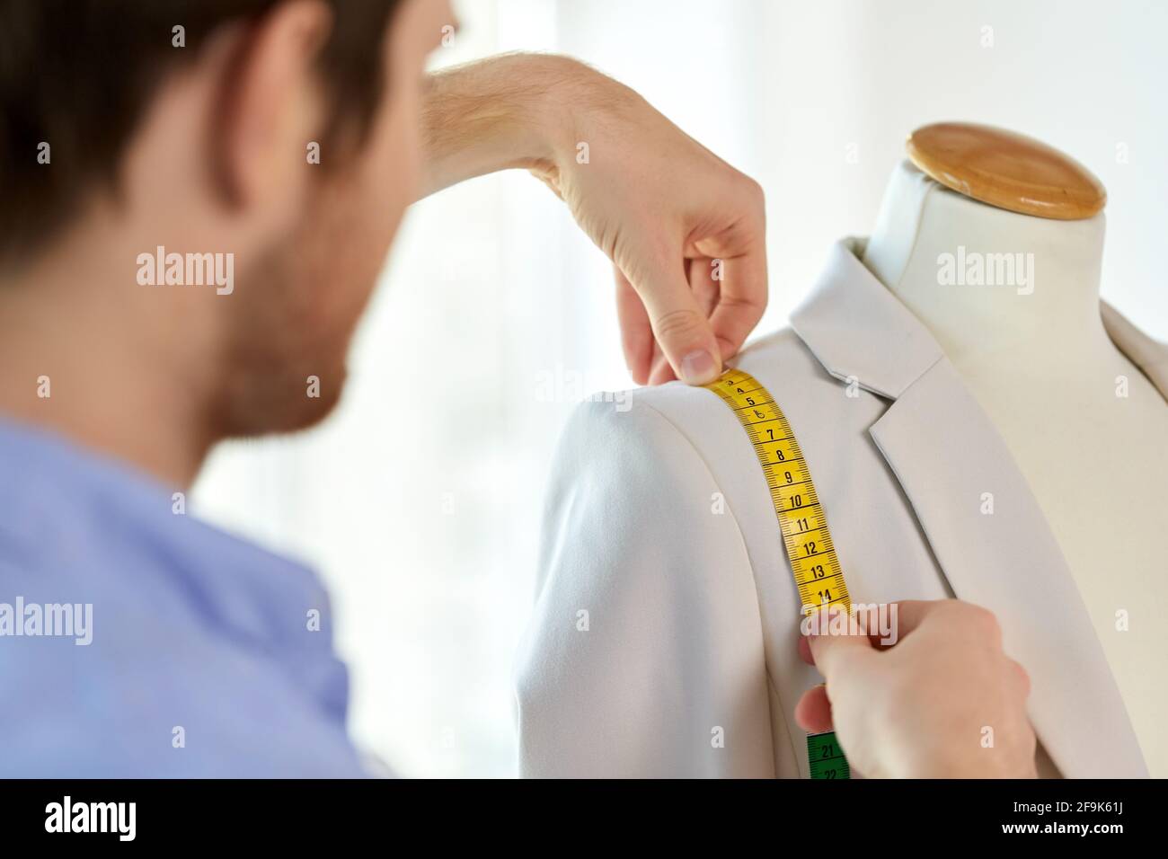 fashion designer measures jacket with tape measure Stock Photo Alamy