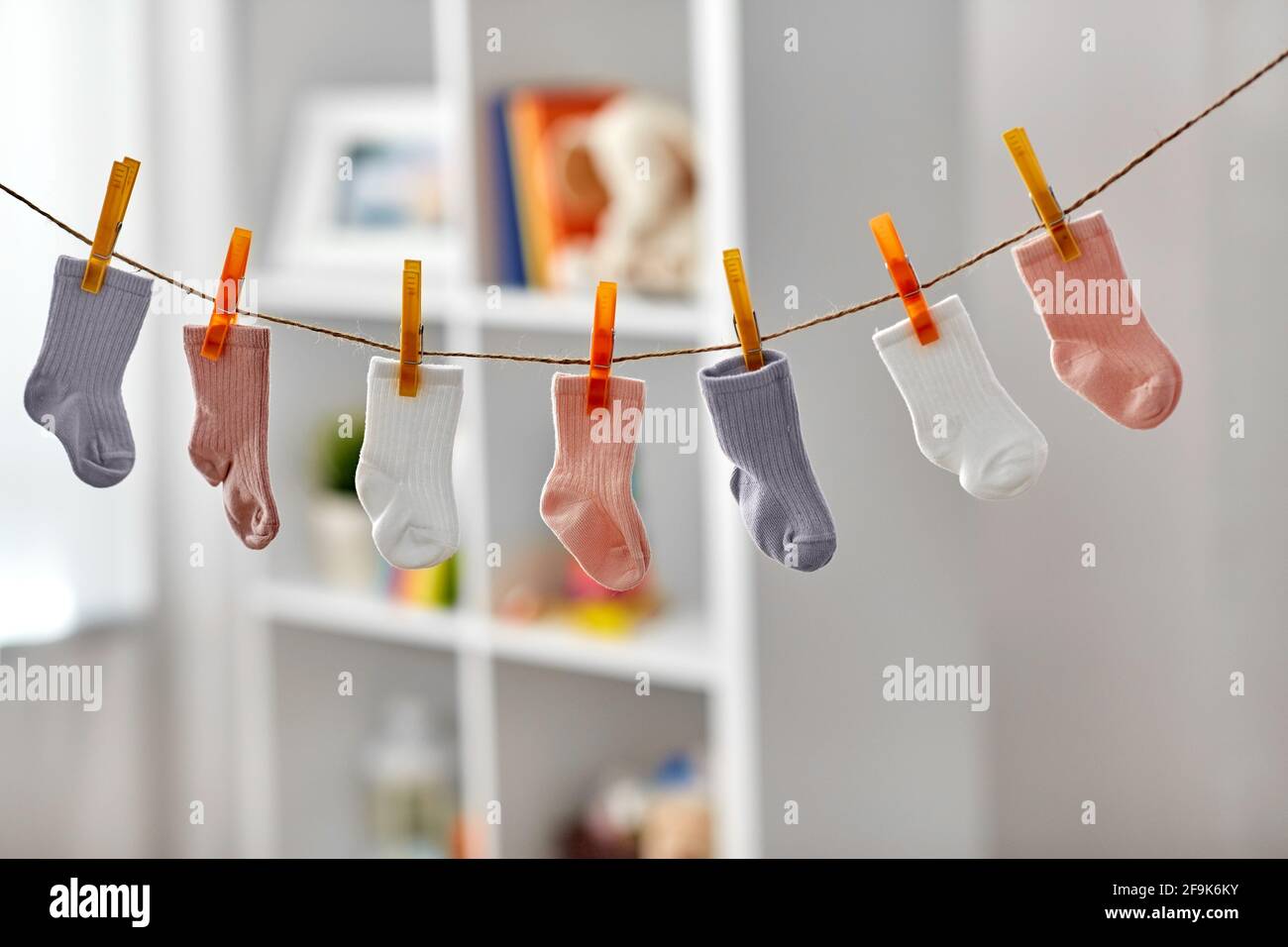 little socks for baby girl on clothesline at home Stock Photo