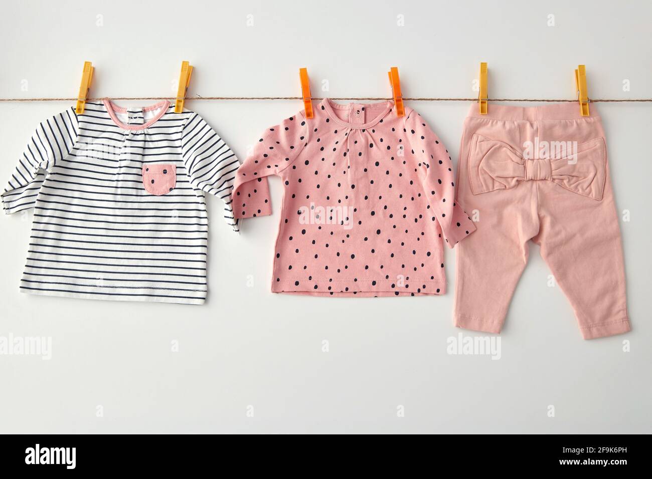 shirts and pants for baby girl on clothesline Stock Photo