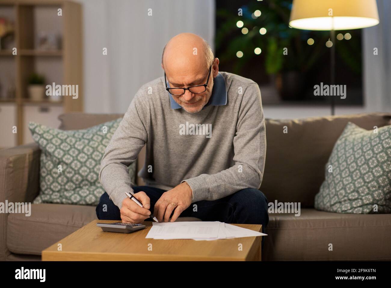 senior man with bills and calculator at home Stock Photo
