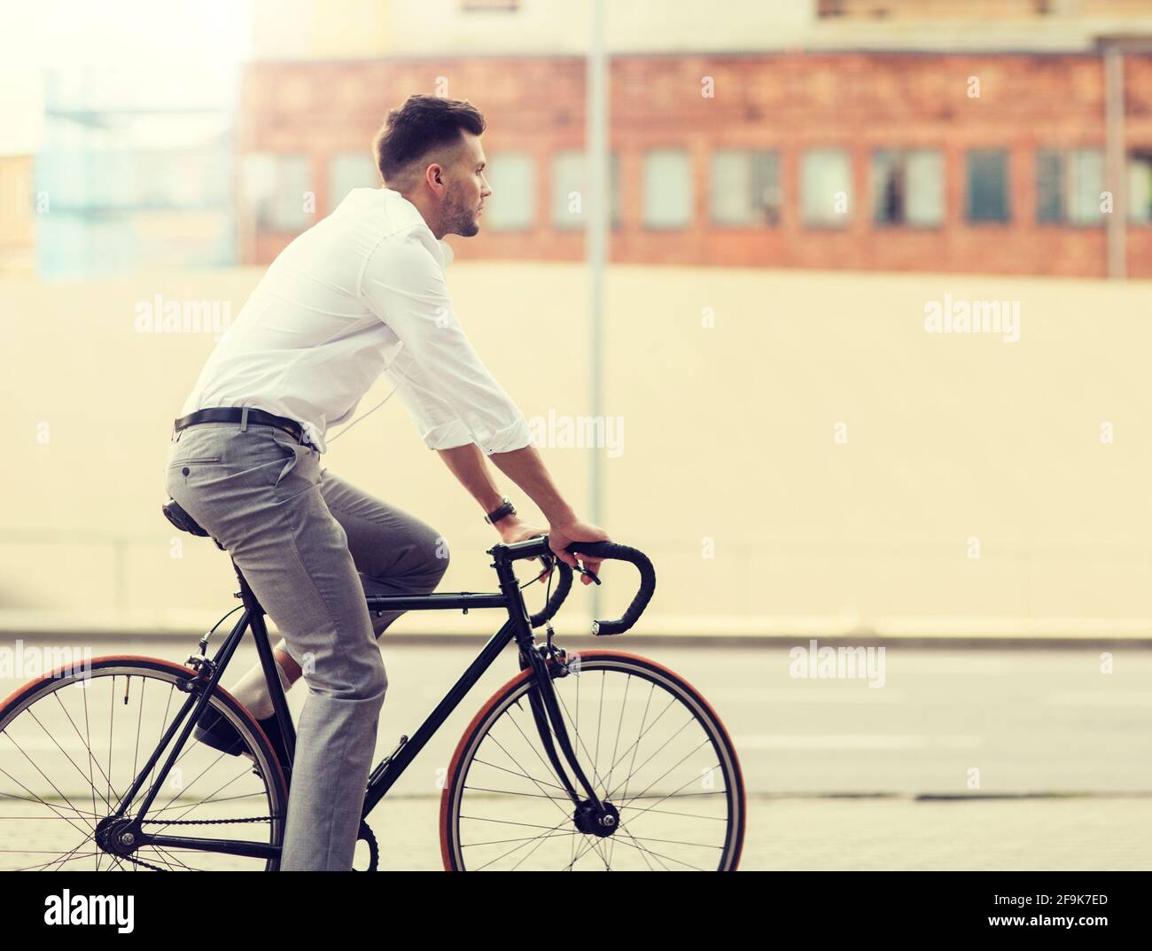 man with headphones riding bicycle on city street Stock Photo