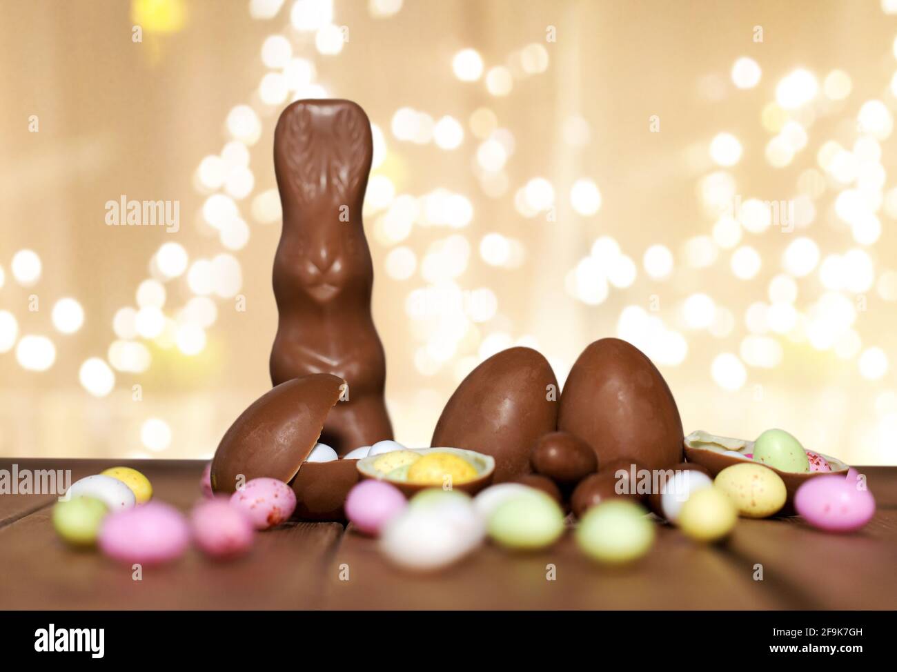 chocolate eggs, easter bunny over festive lights Stock Photo