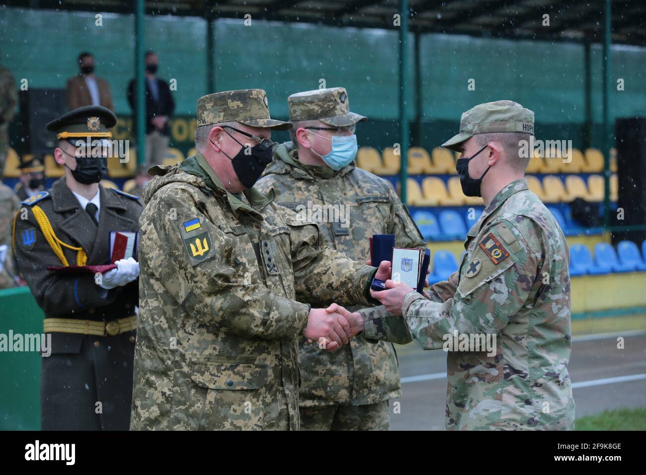 LVIV REGION, UKRAINE - APRIL 16, 2021 - Head of the Hetman Petro Sahaydachnyi National Army Academy Lt Gen Pavlo Tkachuk (L) awards a distinction of t Stock Photo
