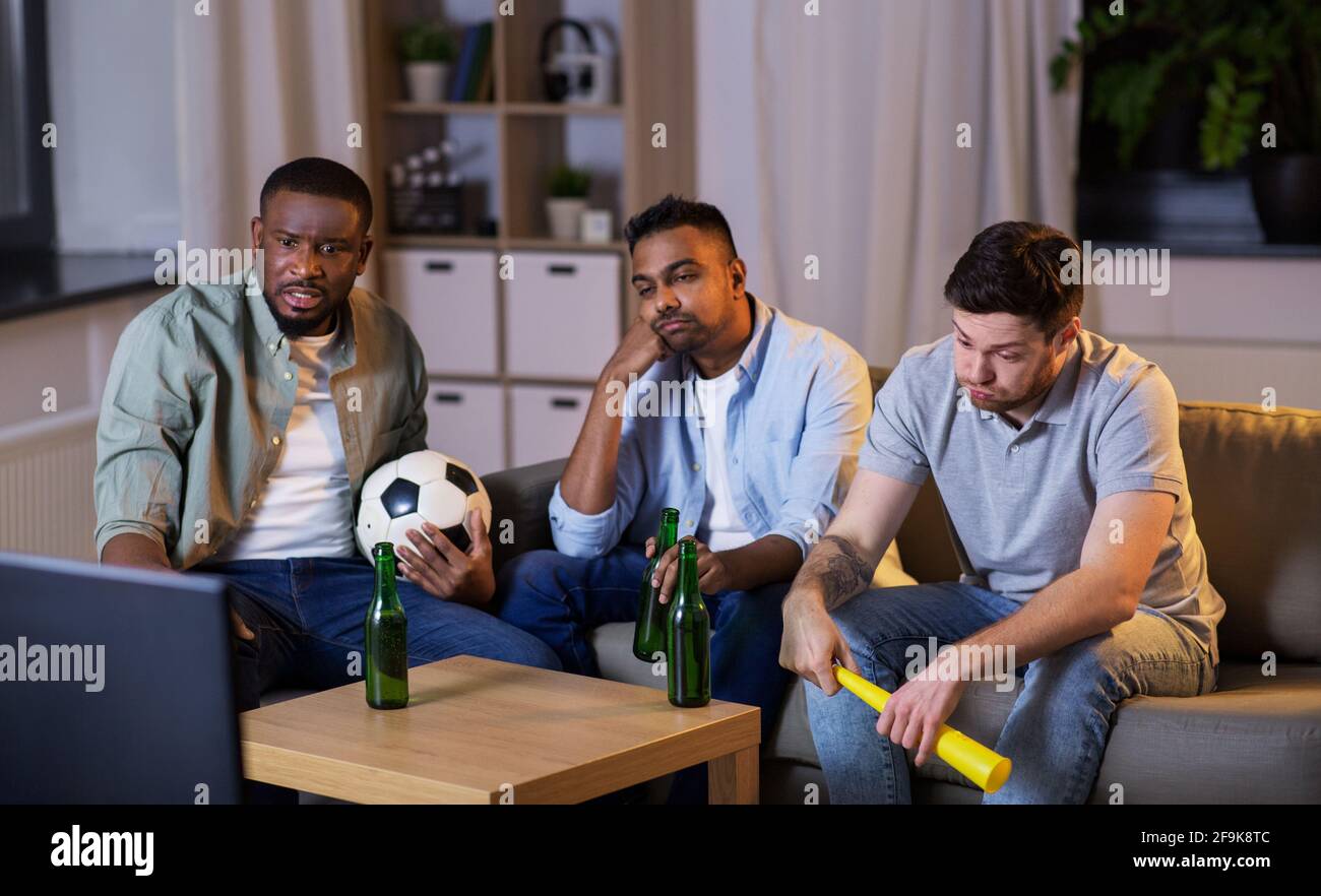 friends with ball and vuvuzela watching soccer Stock Photo