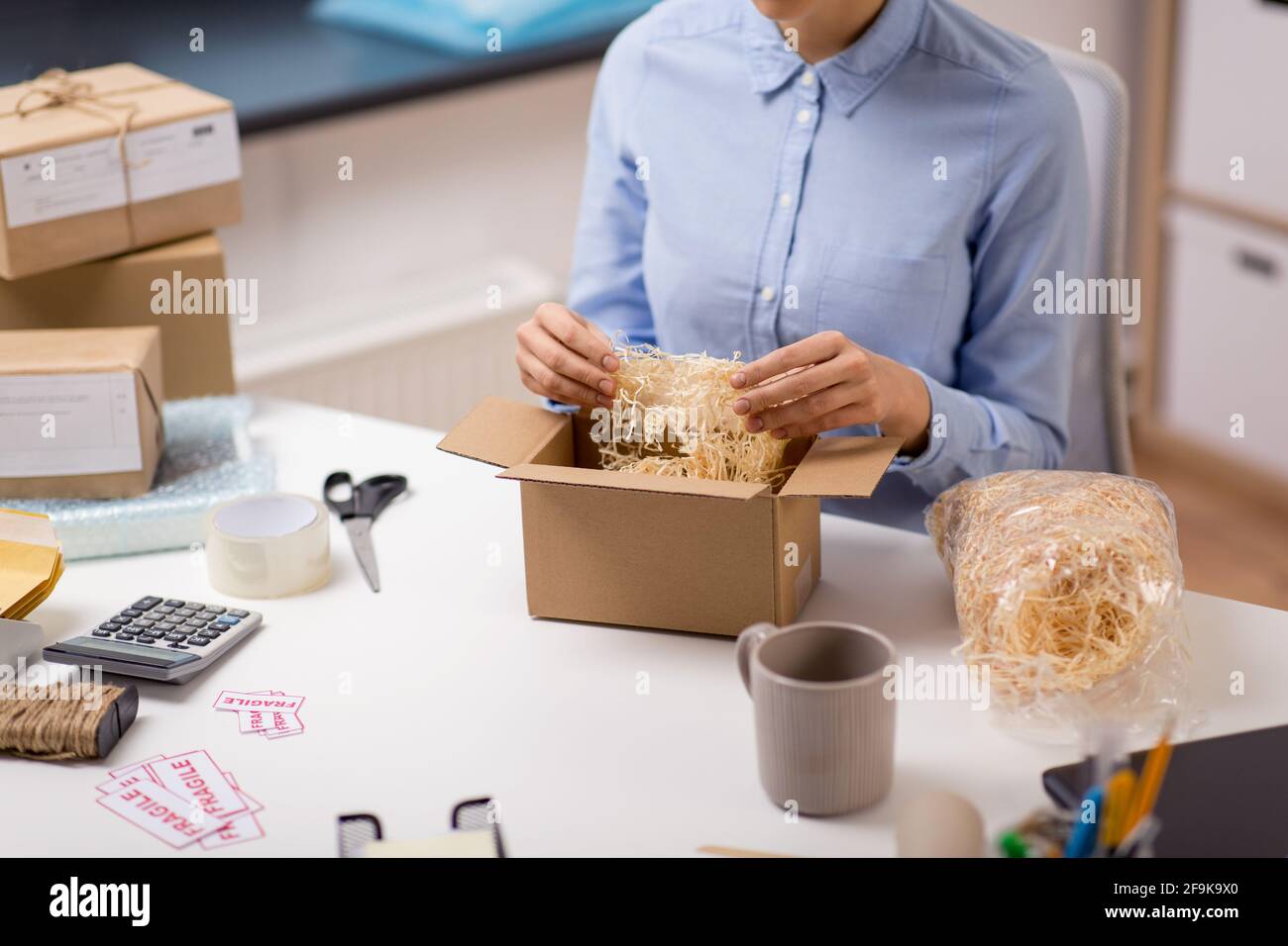 woman sticking fragile marks at post office Stock Photo