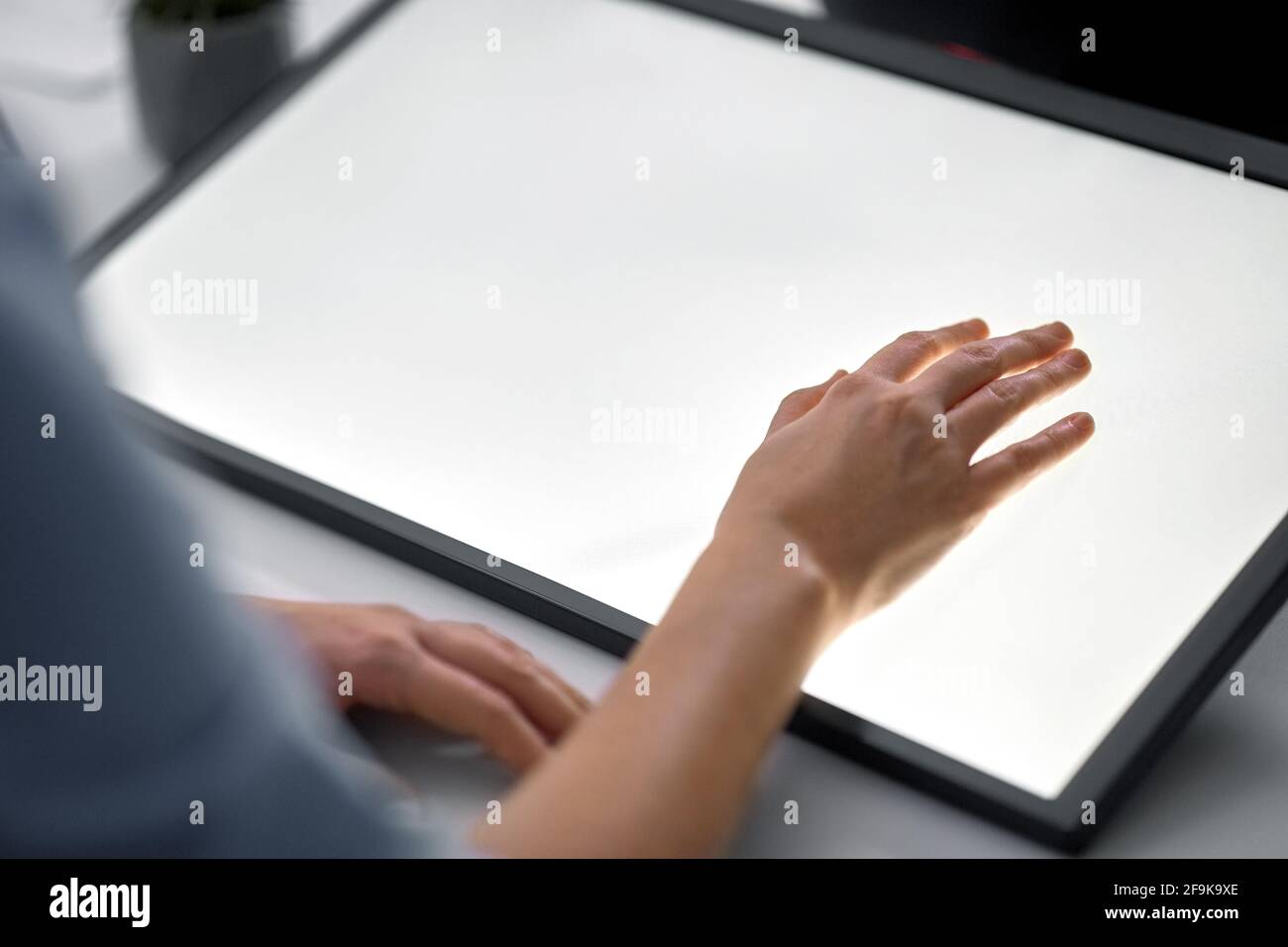 hand on led light tablet at night office Stock Photo