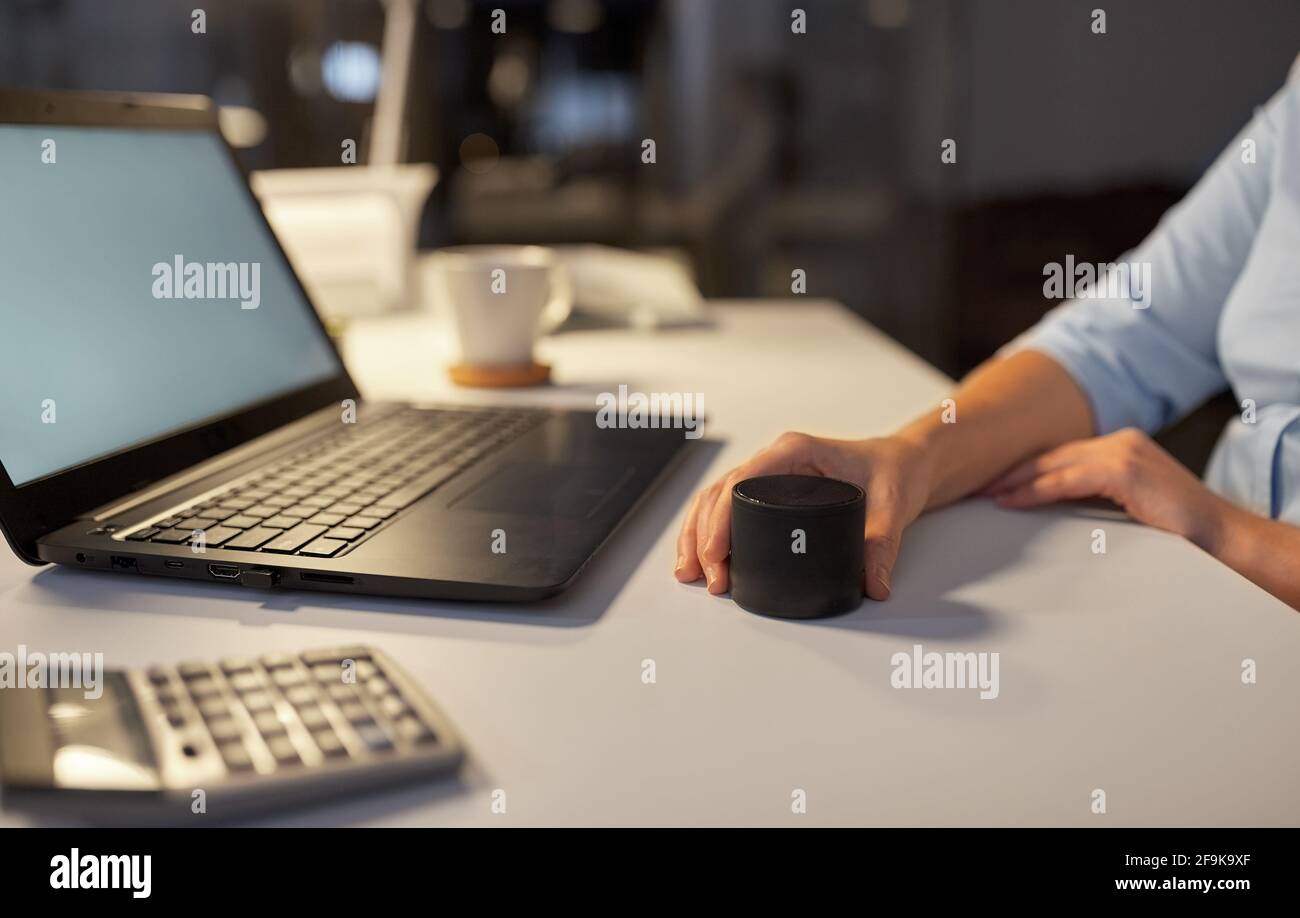 hand using smart speaker at night office Stock Photo