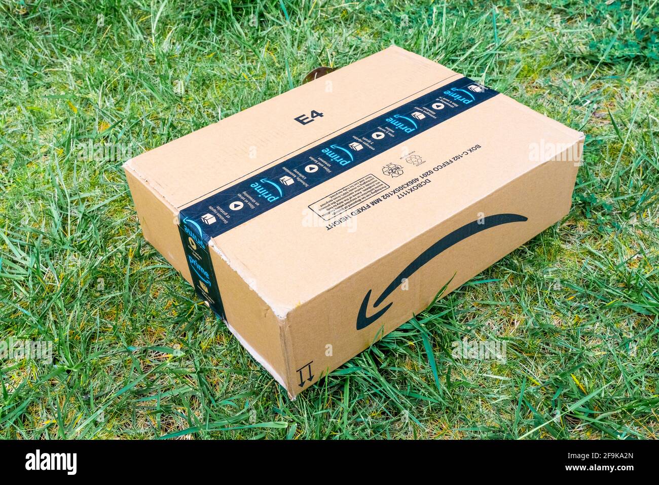 Nice, France- 14.04.2021: View from above of Amazon Prime logotype printed  on cardboard box security scotch tape on the front. Green grass background  Stock Photo - Alamy