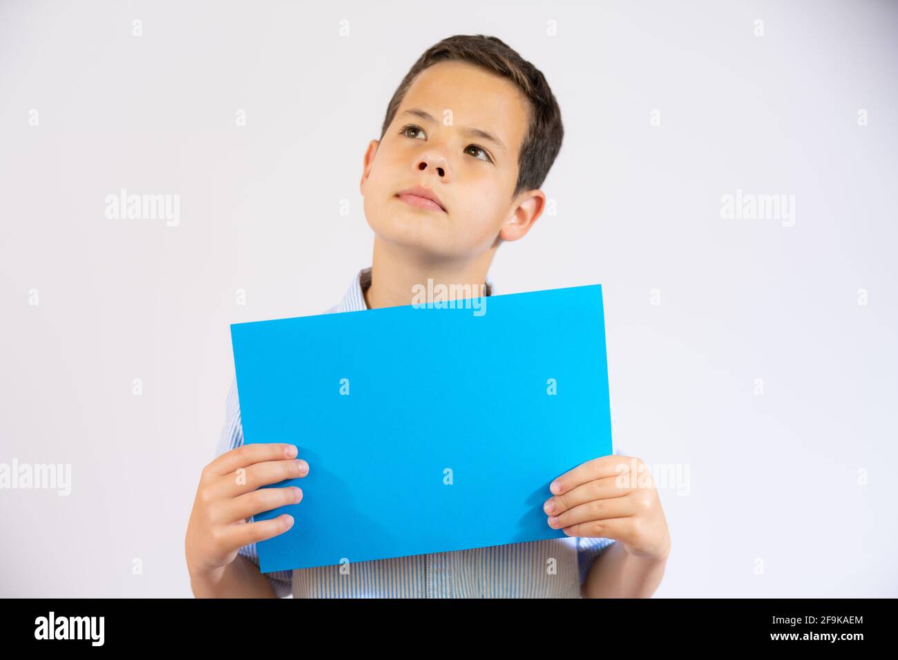 Cute boy holding blue blank paper isolated over white background Stock ...