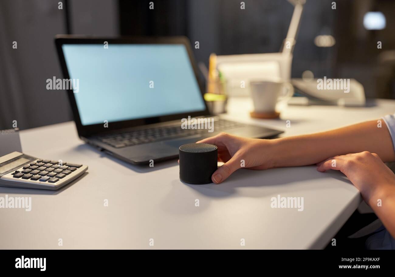 hand using smart speaker at night office Stock Photo
