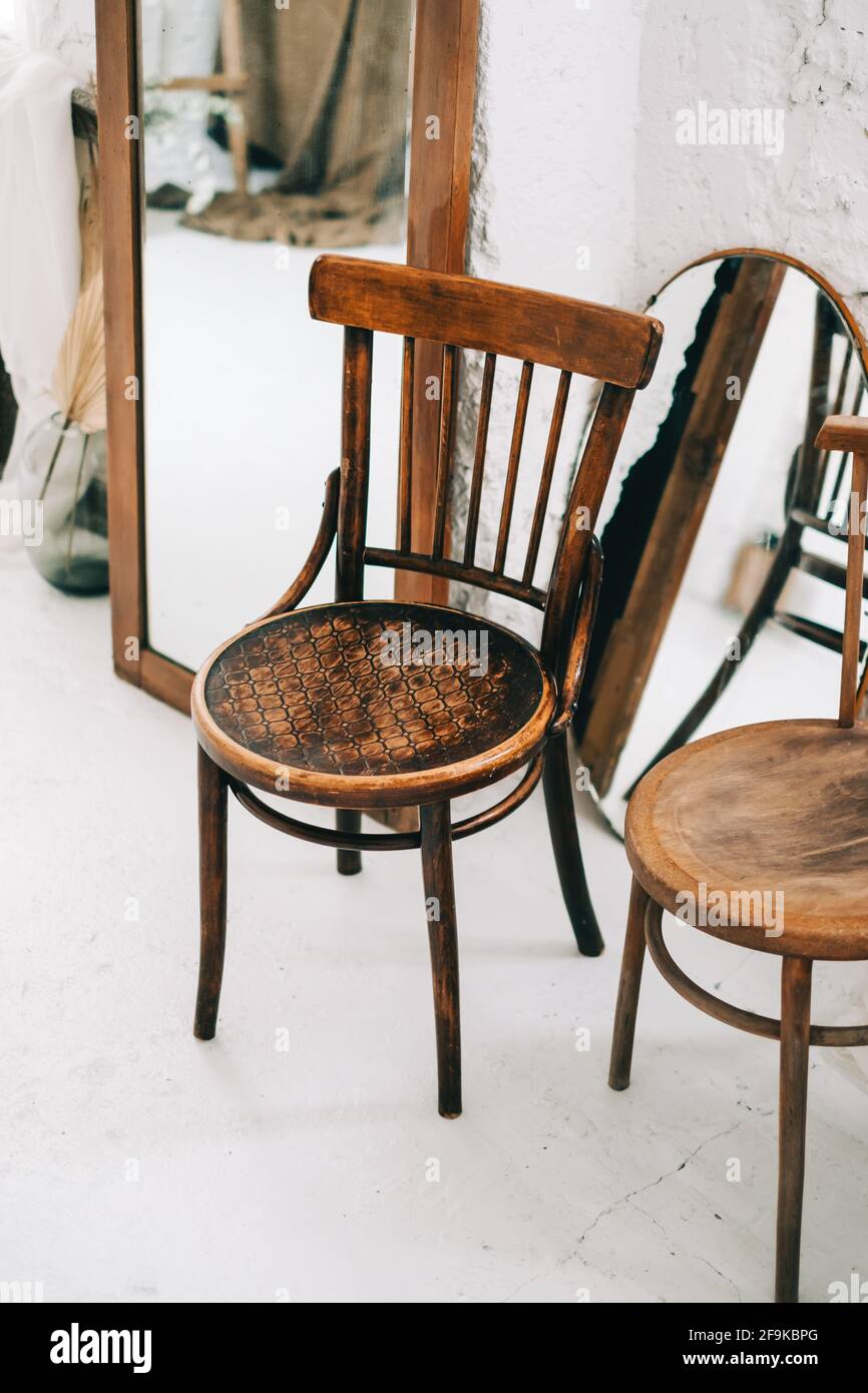 Vintage wooden chairs with mirrors on white floor in living room Stock
