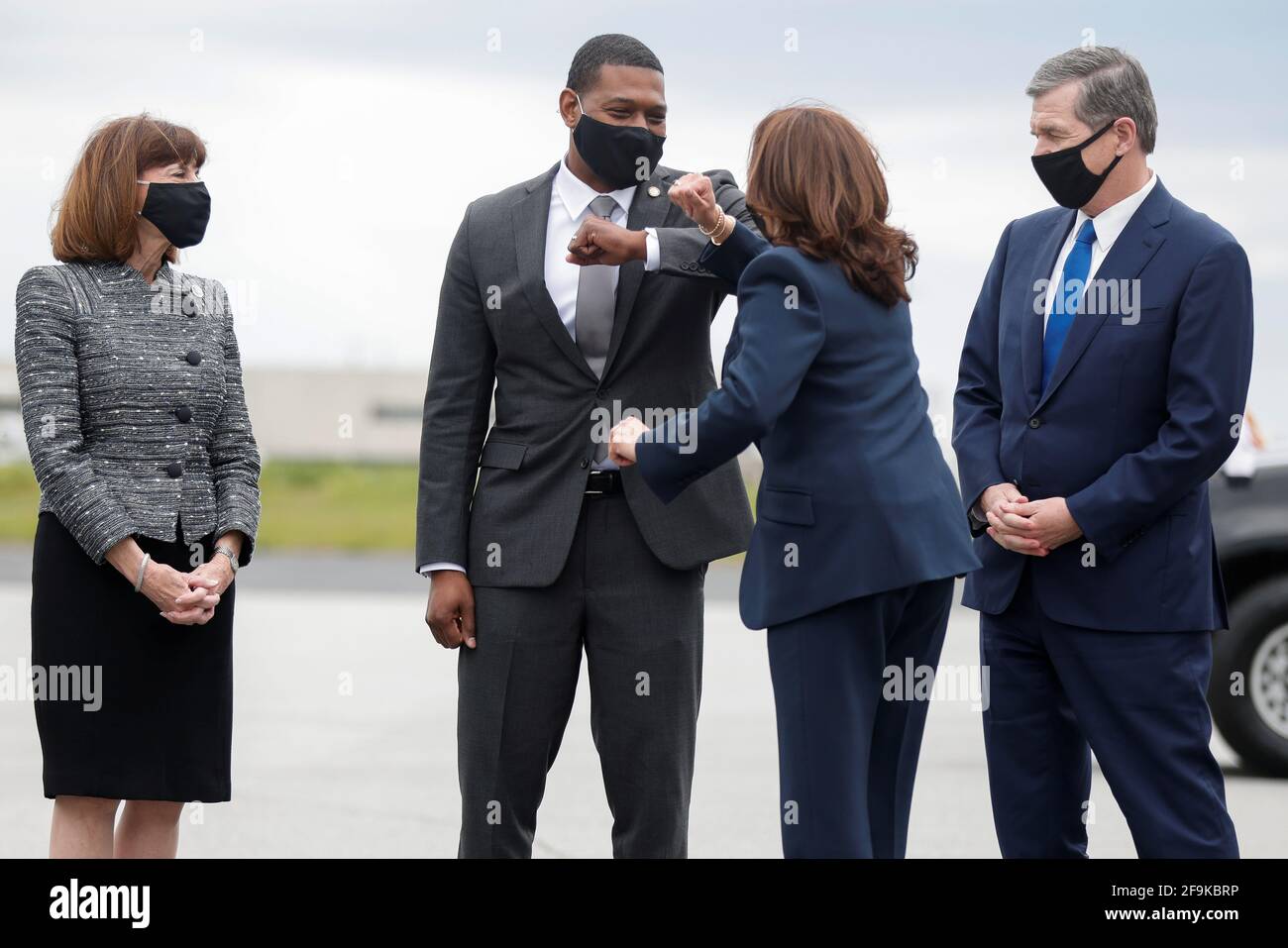 U.S. Vice President Kamala Harris elbow bumps with EPA administrator Michael Reagan next to North Carolina Governor Roy Cooper and Rep. Kathy Manning (D-NC) at Piedmont Triad International Airport in Greensboro, North Carolina, U.S. April 19, 2021. REUTERS/Tom Brenner Stock Photo