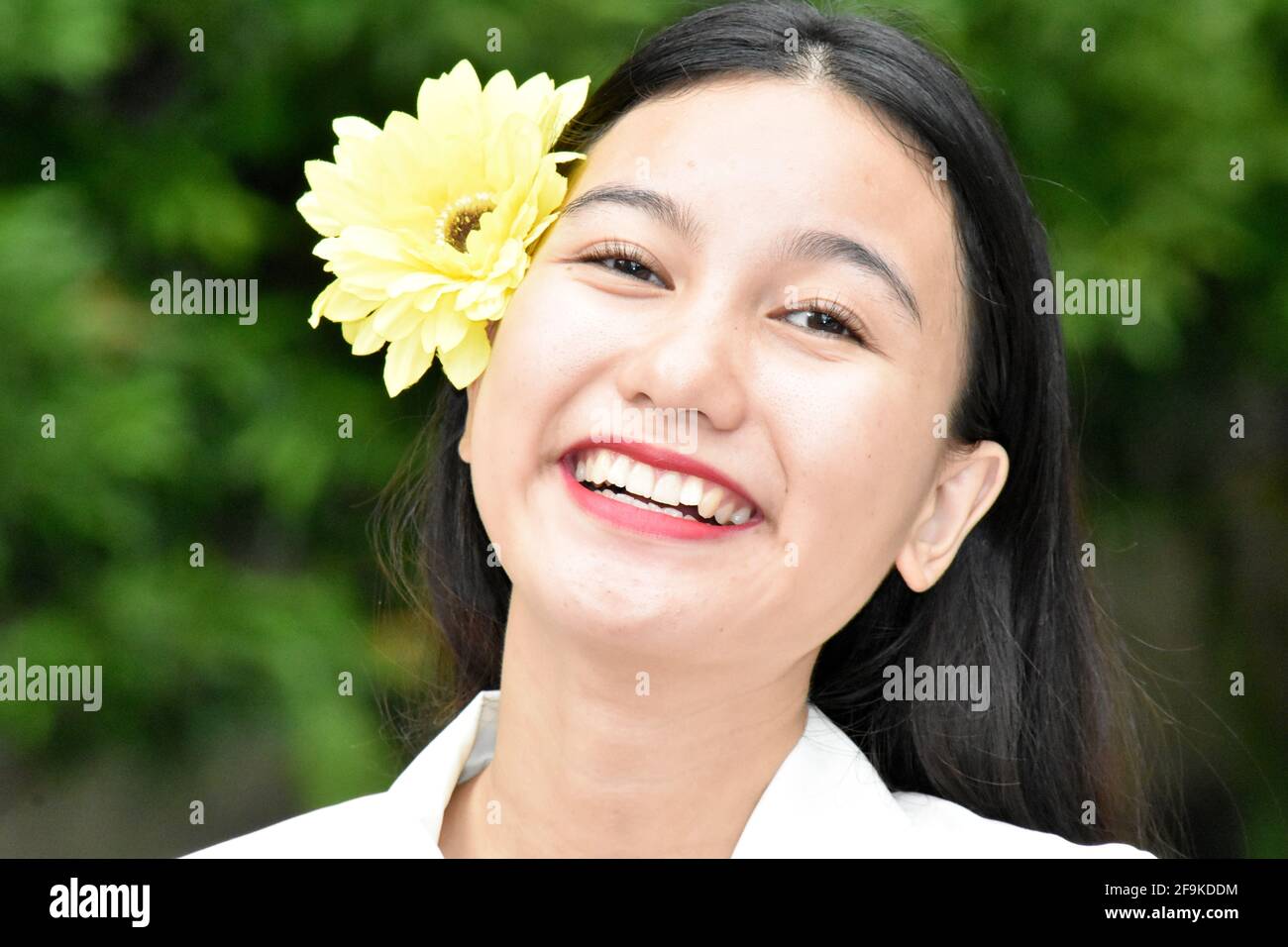 Smiling Youthful Diverse Female With Yellow Flower Stock Photo