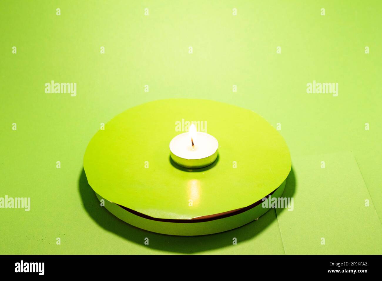 Warming candle small round isolated chromakey glowing fire Stock Photo