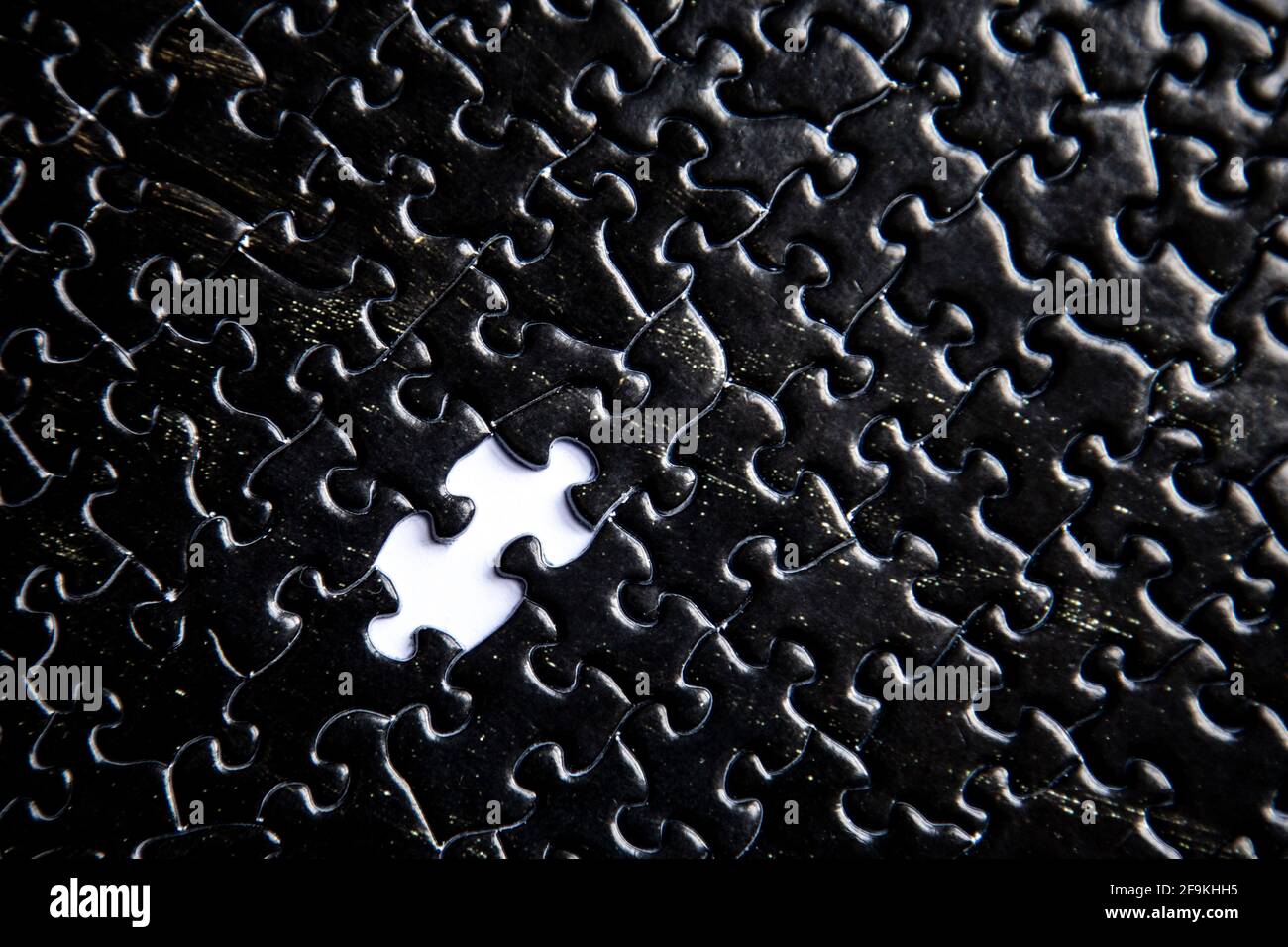 Black jigsaw puzzle pieces background with missing piece Stock Photo