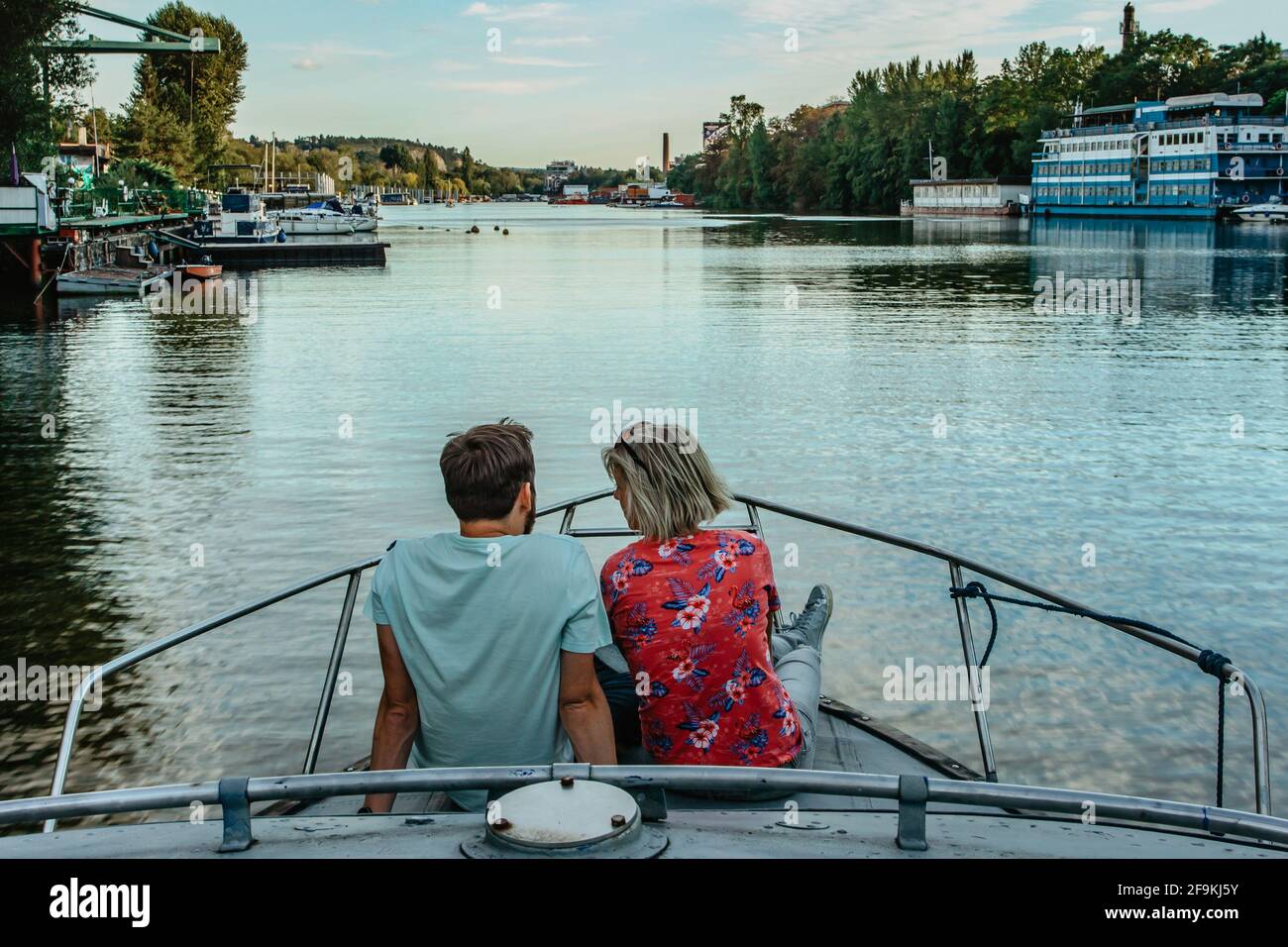 Young happy couple sitting on boat and sailing the river.Man and woman in love having romantic date.Lovers boy and blonde girl on date Stock Photo
