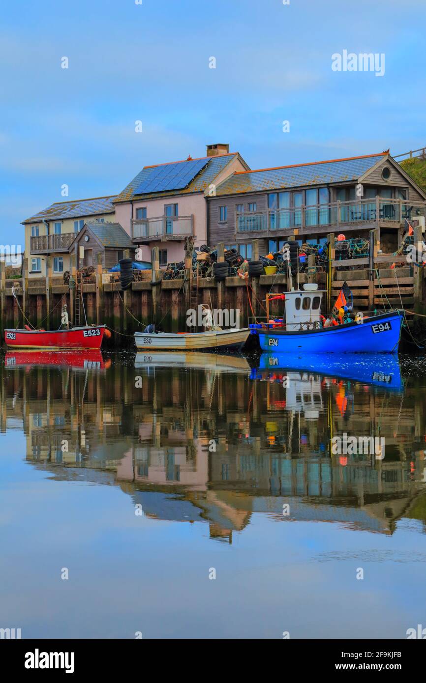 Fishing boats in Axmouth, Devon reflected in river Axe Stock Photo