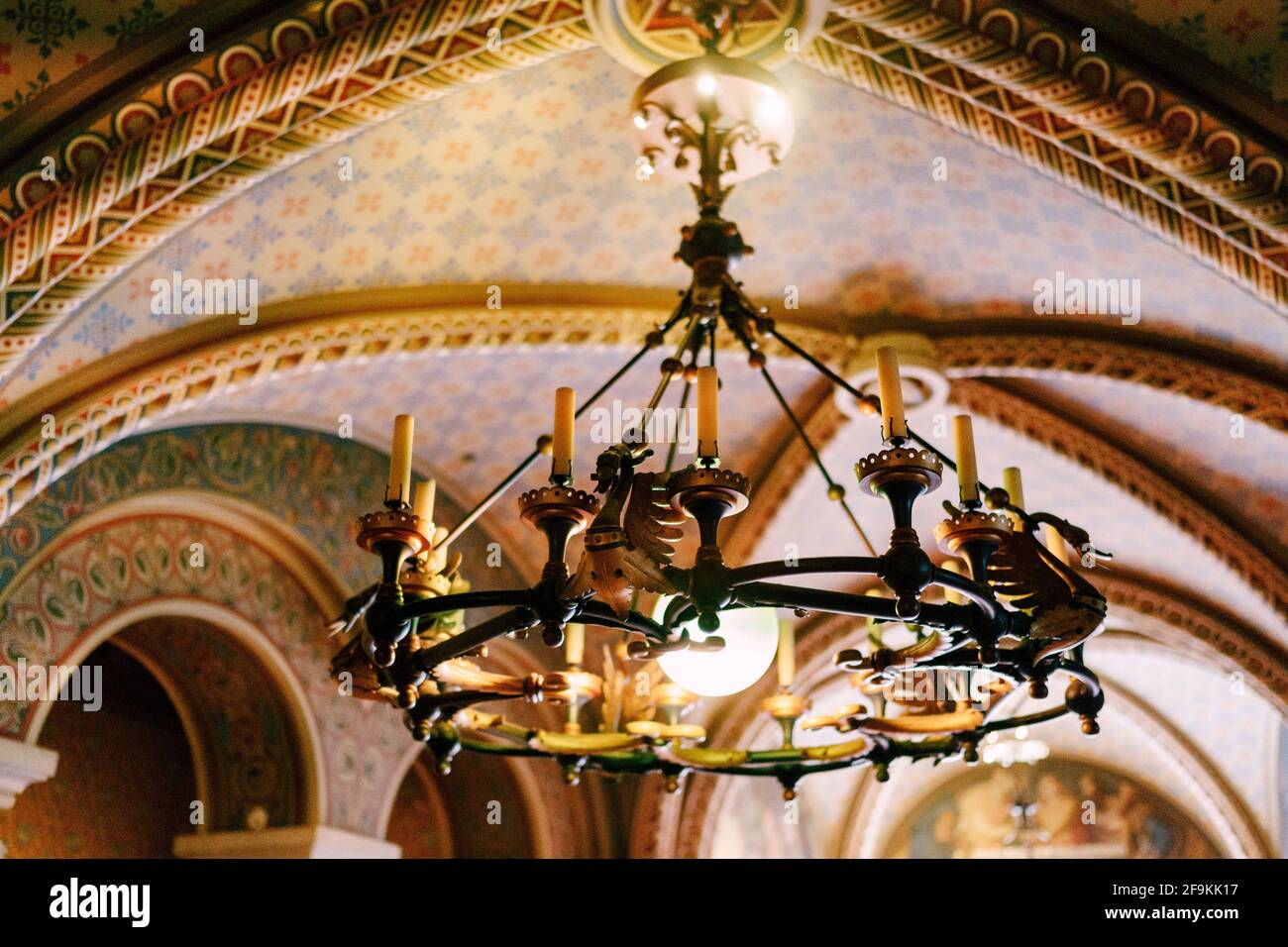 Medieval chandelier with wax candles. Metal chandelier in a castle