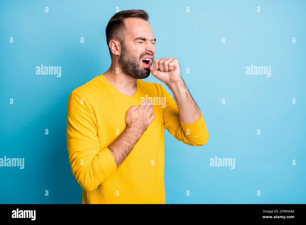 Photo portrait of man having corona virus symptoms cough isolated on bright blue color background Stock Photo